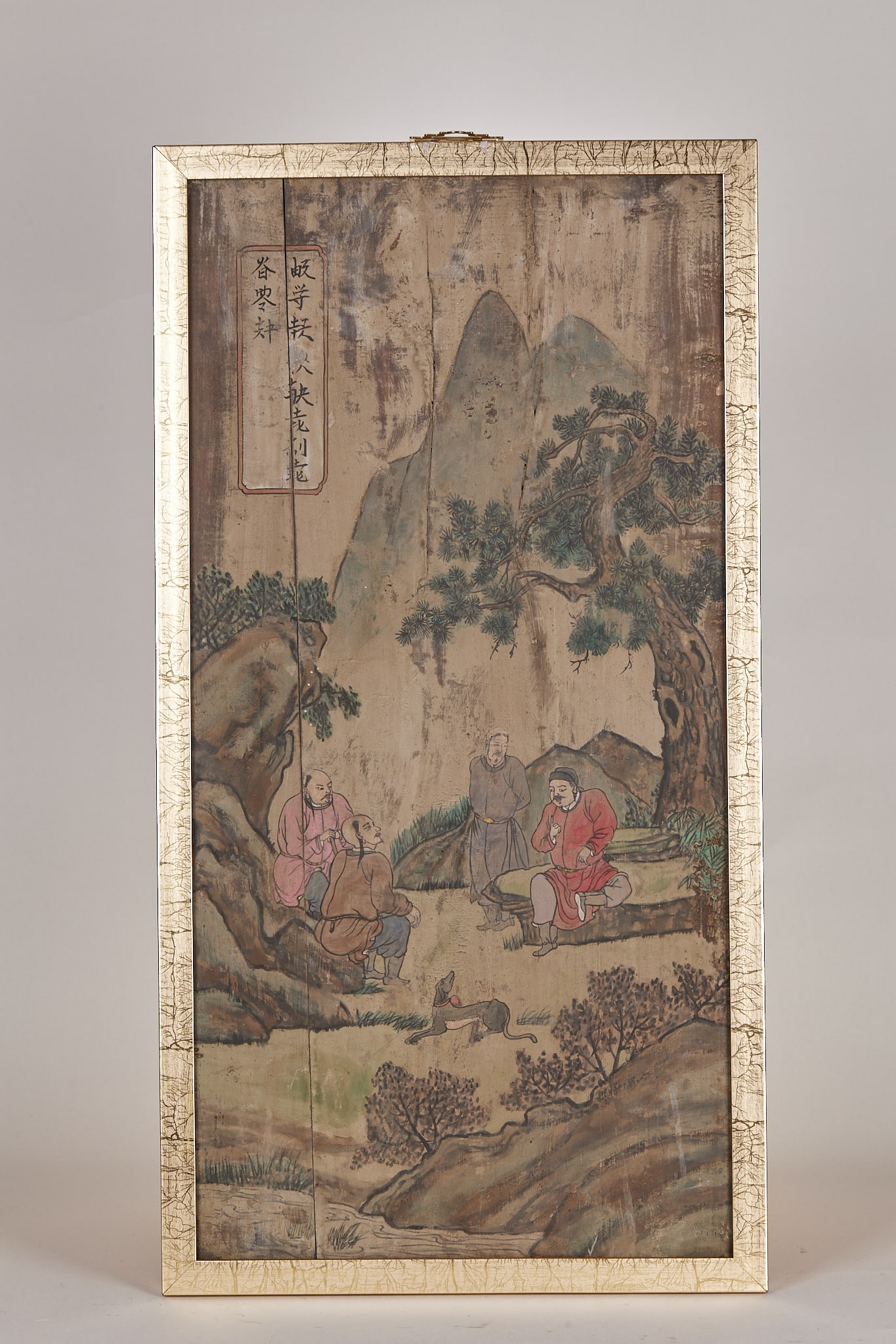 Cypress Plank Painting: A wood panel painted in colour with a landscape-figure scene: four ancients converse amid pines and crags while a hunting dog waits nearby. In the upper left is a vertical Chinese title slip; the