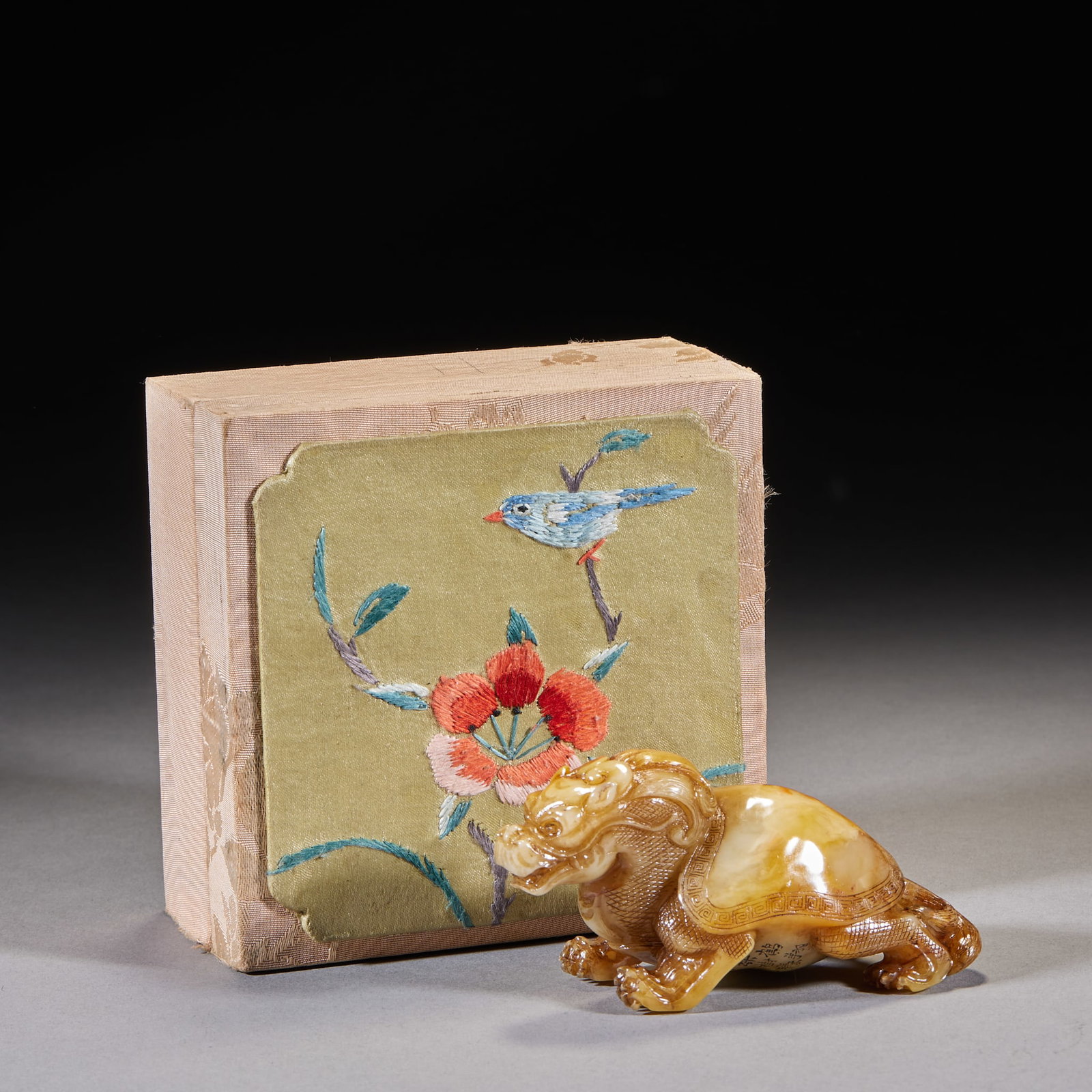 Imperial-Granted Tianhuang Stone Auspicious Beast Hand-Held: A Shoushan stone carving of a dragon-turtle (bi xi), honey-yellow in tone, finely worked with detailed scales and head. Supplied with an old brocade box whose lid is embroidered with flowers and