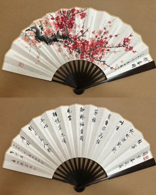 Qi Gong Calligraphy and Plum Blossom Fan: A double-sided folding fan with dark hardwood sticks. One face bears a red plum painting with gnarled branches full of blossoms, inscribed and sealed; the other bears a running-script poem. Painting