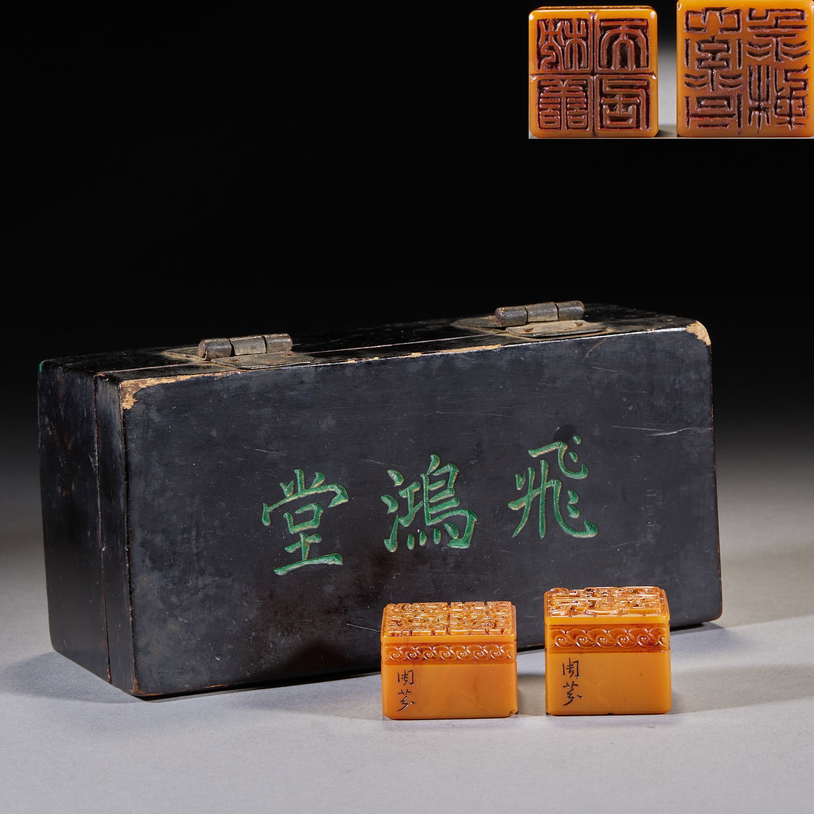 Feihongtang Collection, Two Tianhuang Stone Seals: A black-lacquered wood box with 'Feihongtang' incised and filled green on the lid. Inside are two square tianhuang seals, their bodies carved with layered auspicious-beast motifs and side signatures;