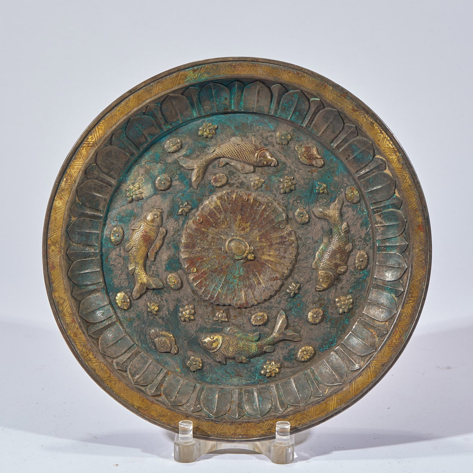 Gilt Silver 'Surplus Year after Year' Display Dish: A round silver dish with gilt rim and decoration. The centre bears a lotus-petal principal motif; the face is engraved with four swimming fish amid lotus, waterweeds, turtles and shells, bordered by