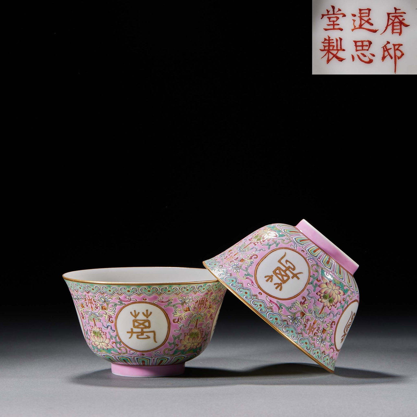 Pair of 'Wan Shou Wu Jiang' Tea Bowls, Ruidi Tuisi Tang-Marked, Famille-Rose: Late-Qing famille-rose porcelain bowls with the base mark 'Made at the Ruidi Tuisi Hall'. The rose ground bears scrolling lotus with four panels inscribed in gilt 'Wan Shou' (ten-thousand long life).