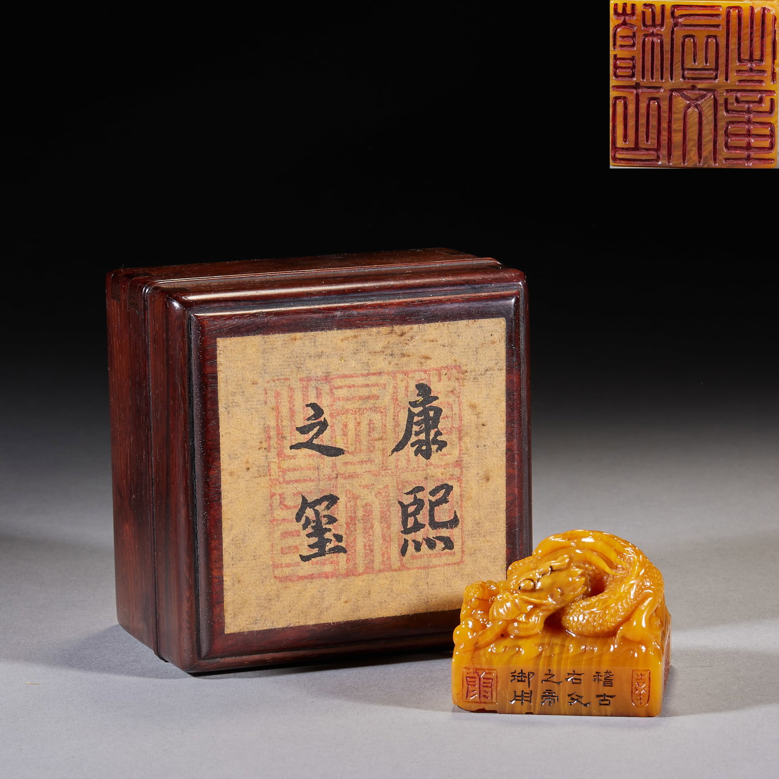 Tianhuang Stone Seal 'Kangxi's Treasure, Imperial Use of the Emperor Who Reveres Antiquity and: Of tianhuang stone with a carved coiled-dragon knop; the wooden box is inscribed 'Seal of Kangxi' and the side reads 'For the imperial use of the emperor who reveres antiquity and culture'. Tianhuang