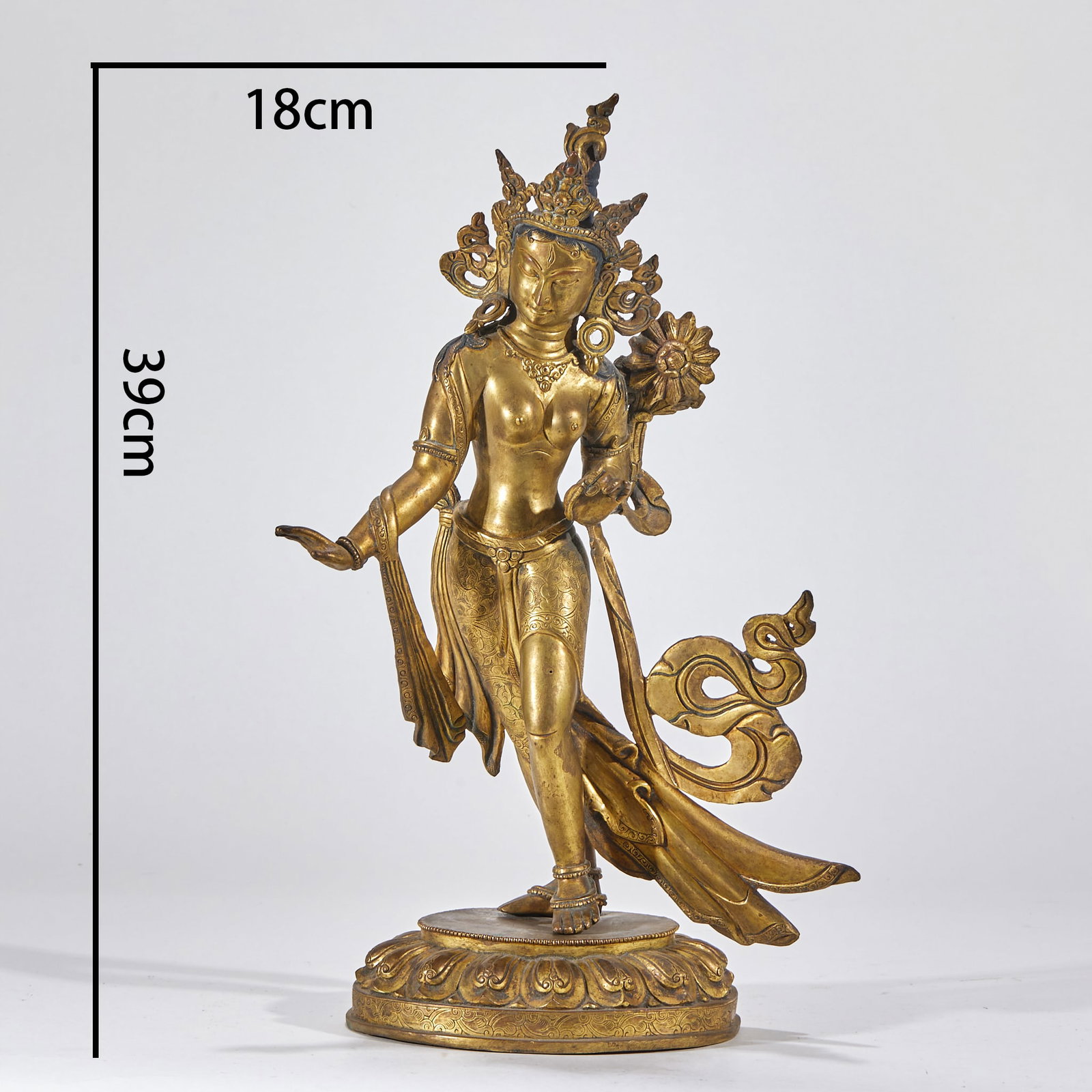 Gilt Copper Tara Statue: Gilt-copper image, H 39 cm. The Tara stands elegantly in a graceful posture, wearing a crown and jewelry; the right hand makes the fearless mudra, the left holds a lotus, over a double-lotus base. A