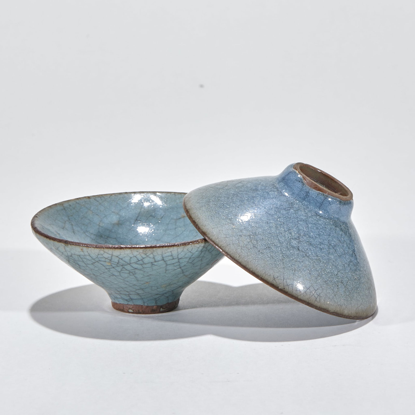 Pair of Ru-Kiln Ice-Crackle Conical-Hat Bowls: Song-dynasty Jun ware in classic conical-hat form with open mouth, slanted walls and small foot ring. The sky-blue glaze is densely crazed; the mouth rim and foot ring show the body in brown. Jun