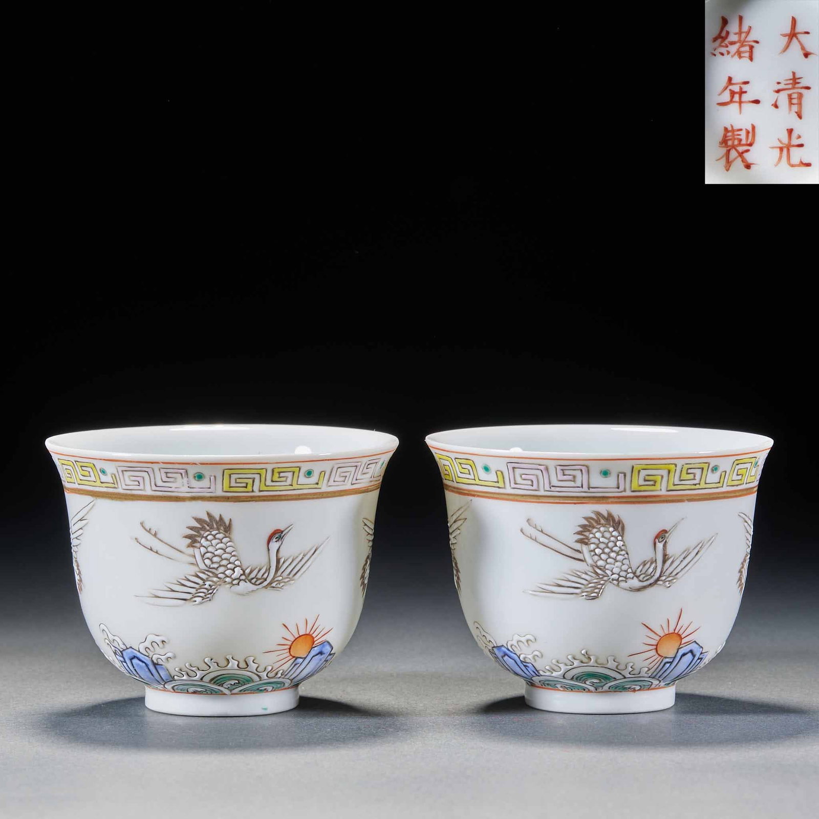 Pair of Famille-Rose Crane Cups, Guangxu Period: White porcelain bodies painted in famille-rose with cranes, sea-and-mountain waves and a rising sun, rimmed with meander. Cranes symbolise longevity and the waves firmness of the state ?? late-Qing