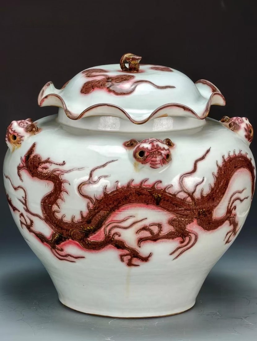 Copper-Red Dragon Covered Jar with Lotus-Leaf Cover: A lotus-leaf-shaped cover; the body has beast-head loop ears and is painted throughout with a large copper-red dragon. Copper-red firing is extremely difficult; the red dragon is imposing and the