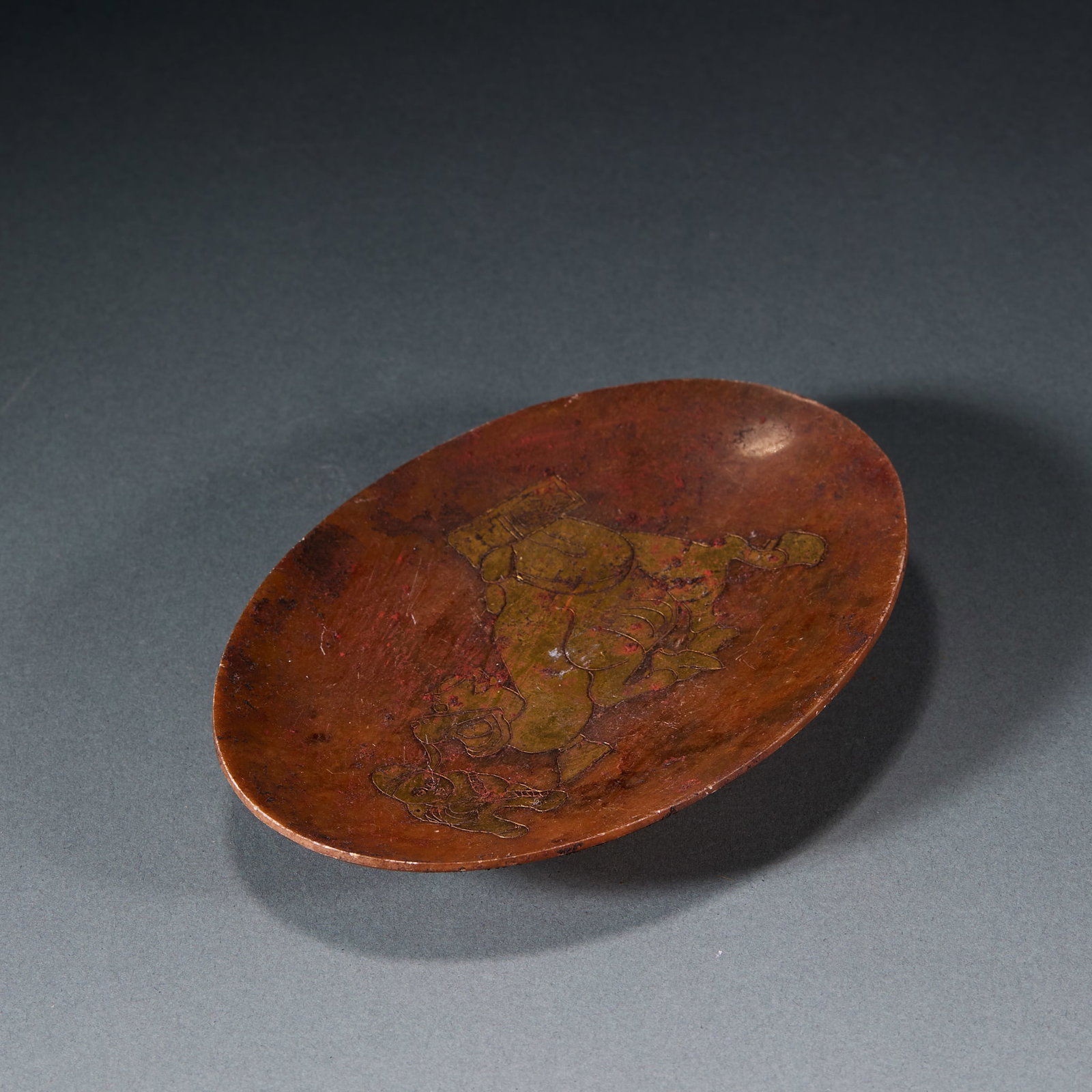 Gold-Traced Jade Figure Dish: A shallow copper dish engraved on the face with a figure scene; oval, reddish-brown skin with the patina of long use, to hold incense ash as a scent-ritual vessel or a scholar's tray. H 1.9 cm, L 15