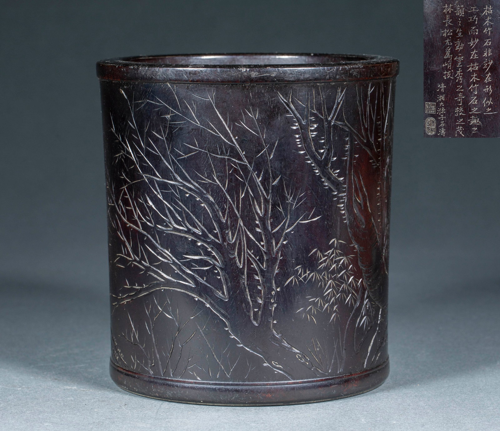 Qing Zitan Brush Pot Inscribed with Poetry and Flowers: A zitan brush pot carved from one block; the body is lightly carved with dead trees, bamboo and rocks in the manner of painting, with Shi Tao's poem and seals incised at the upper right. The wood is