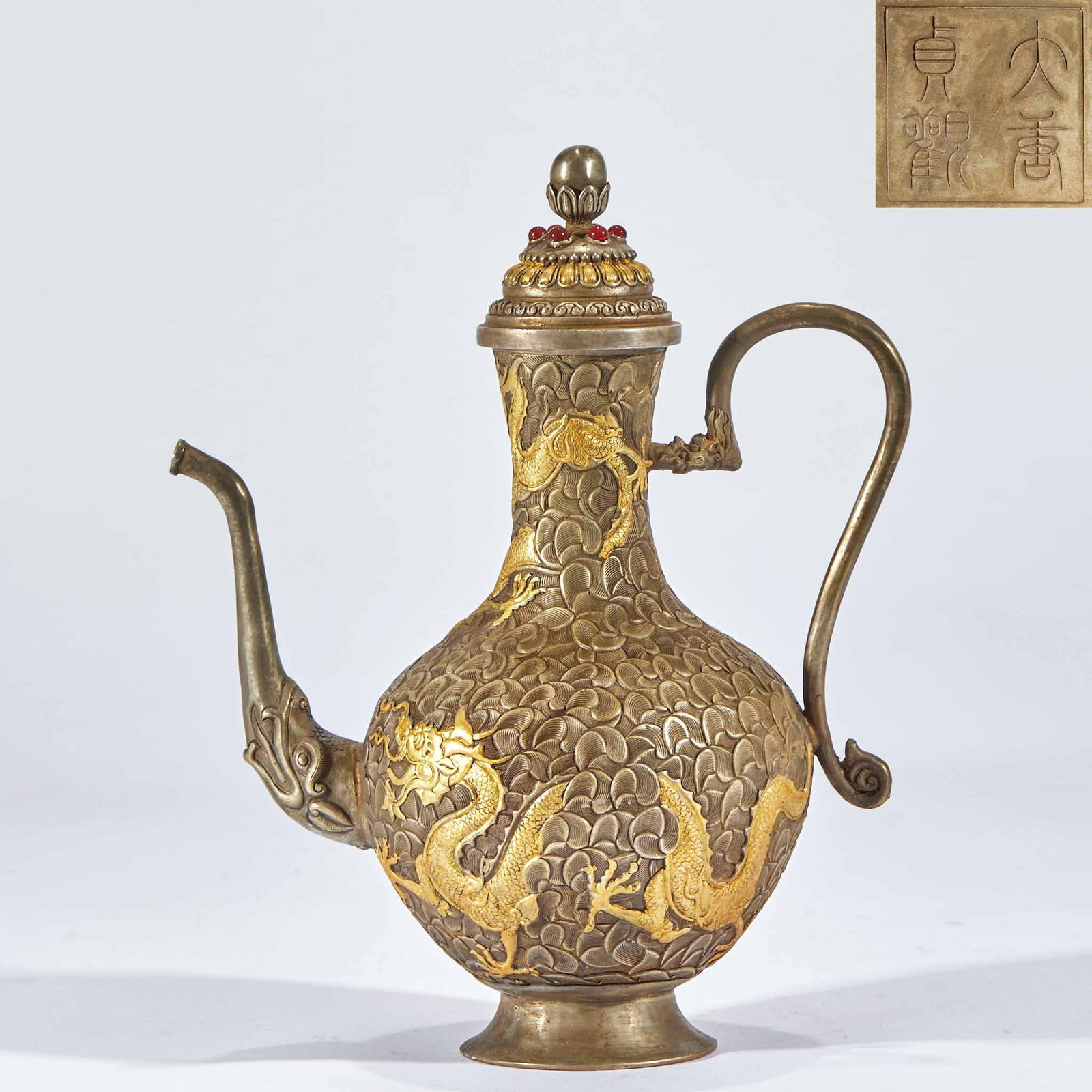 Partially Gilt Copper Dragon Ewer, 'Zhenguan' of the Great Tang: A silver-bodied partially gilt ewer with the base mark 'Daqing Zhenguan' (Great Tang Zhenguan). The body is densely carved with ground patterns and high-relief gilded walking-dragons threading amid cl
