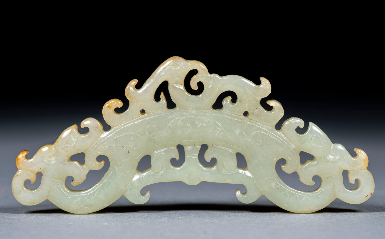 Openwork Phoenix Twin-Dragon Jade Huang: Of Hetian greenish-white jade cut by openwork and intaglio; the principal is an arc with twin dragons supporting it and a phoenix above, covered with cloud scrolls and partly naturally calcified. Imit
