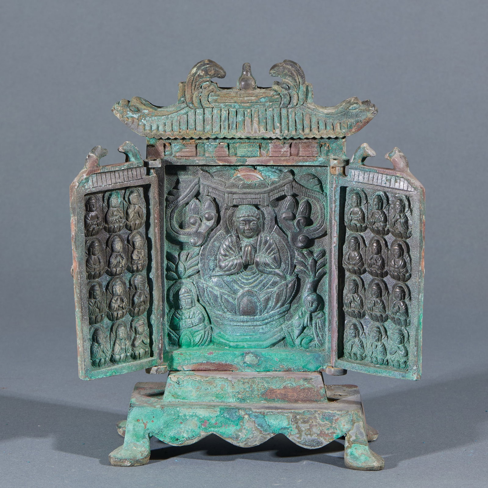 Bronze Buddha Shrine, Buddha Preaching: A bronze multi-treasure shrine with an imitation wooden pavilion roof and double doors. The principal Buddha sits in lotus position inside; the door leaves are carved in relief with many small