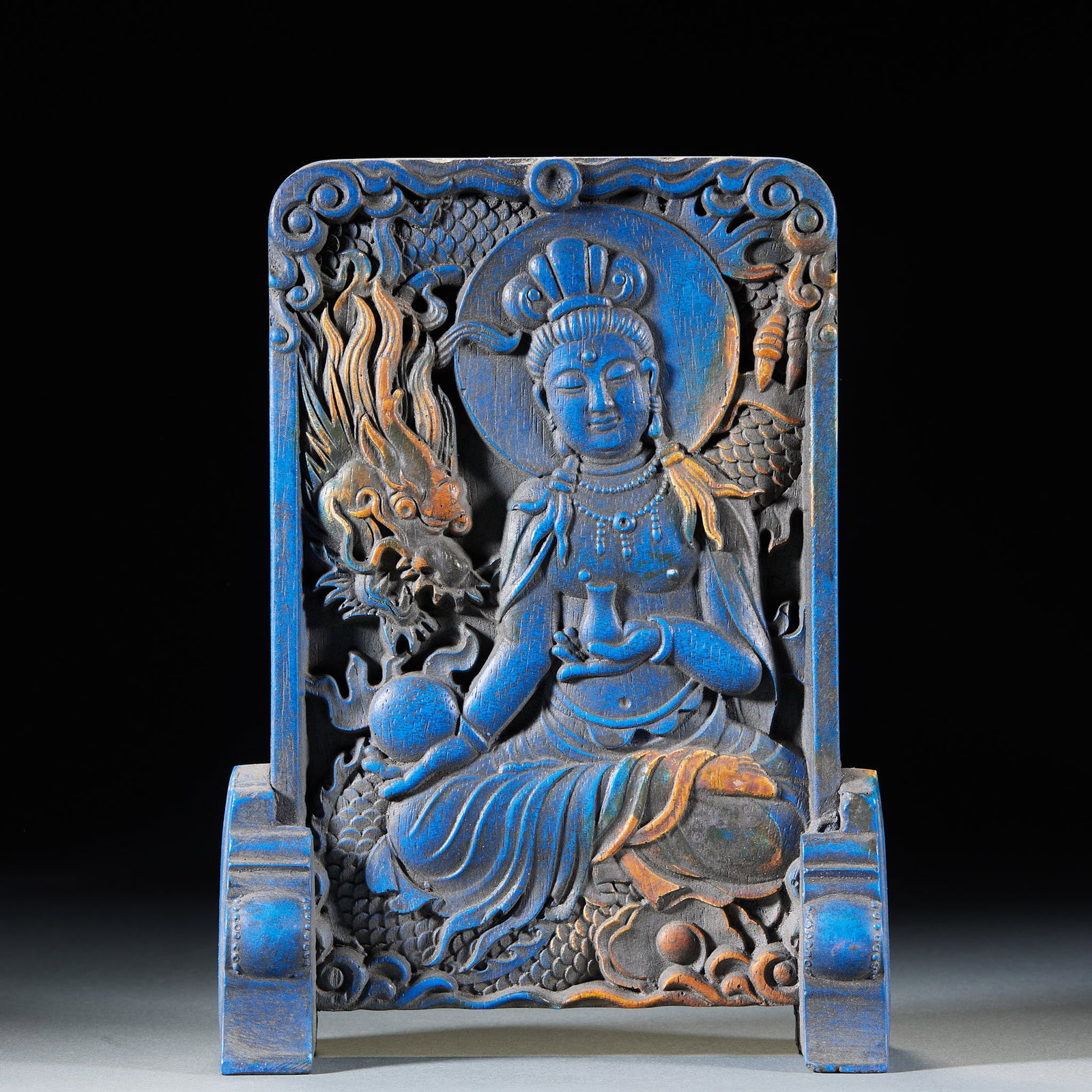Lapis Lazuli Guanyin Table Screen: Wood-bodied relief carved and coloured overall in mineral pigments led by azurite. The Guanyin sits upon a divine dragon, one hand holding a pure-vase, surrounded by auspicious clouds and dragons, on 