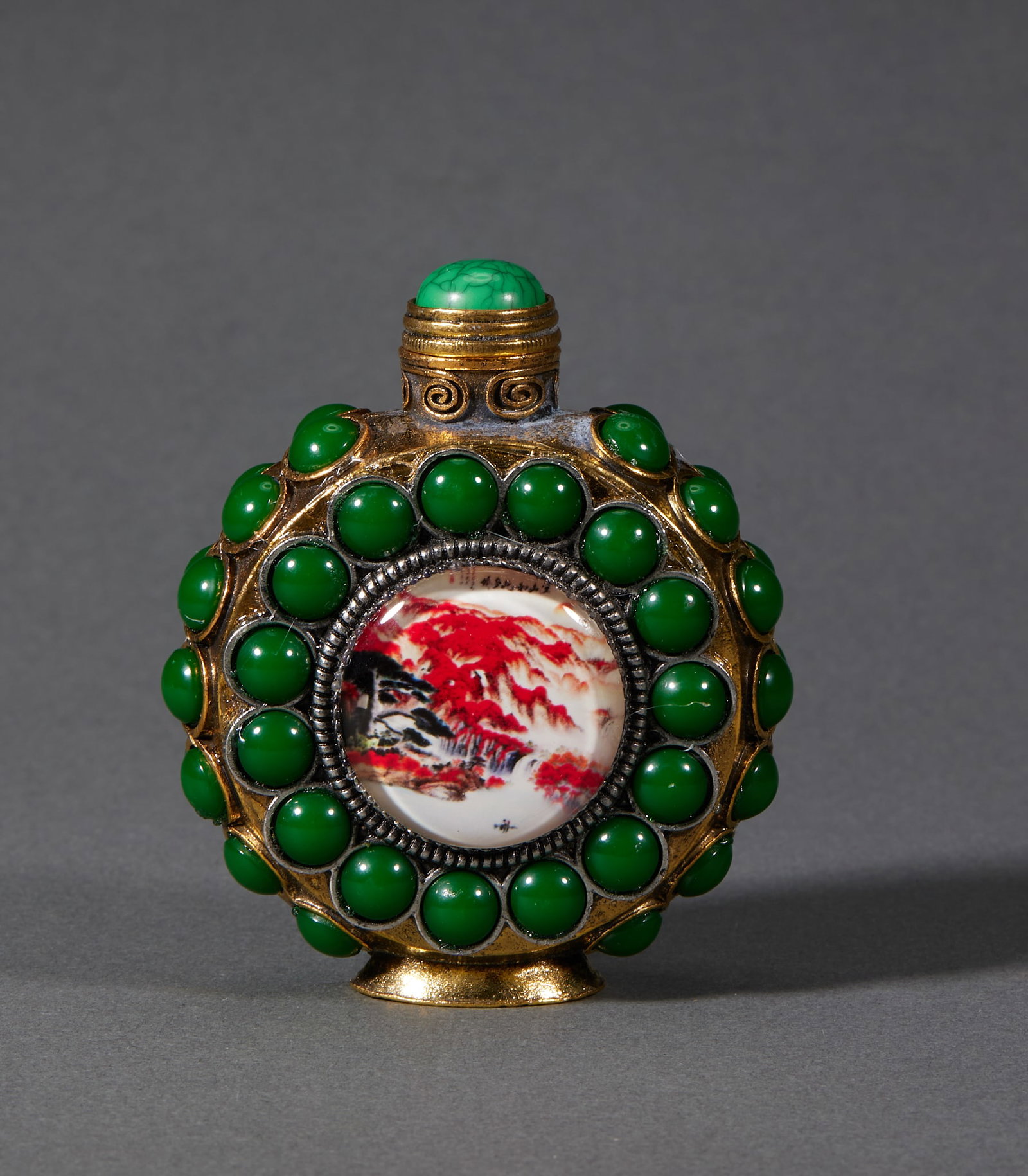 Qing Inlaid Panel Landscape Snuff Bottle: The body is gilt-copper, encircled with inlaid deep-green round beads; the front has a round panel with an interior-painted scene of autumn mountains and red trees, fitted with a turquoise stopper.