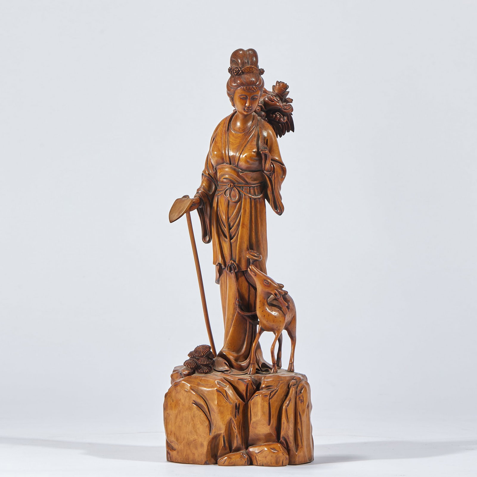 Boxwood Magu Offering Longevity: A boxwood round carving of Magu (goddess of longevity) presenting a peach, graceful pose, flowing robes, kindly face, accompanied by a deer and lingzhi ?? auspicious symbols of long life. The boxwood