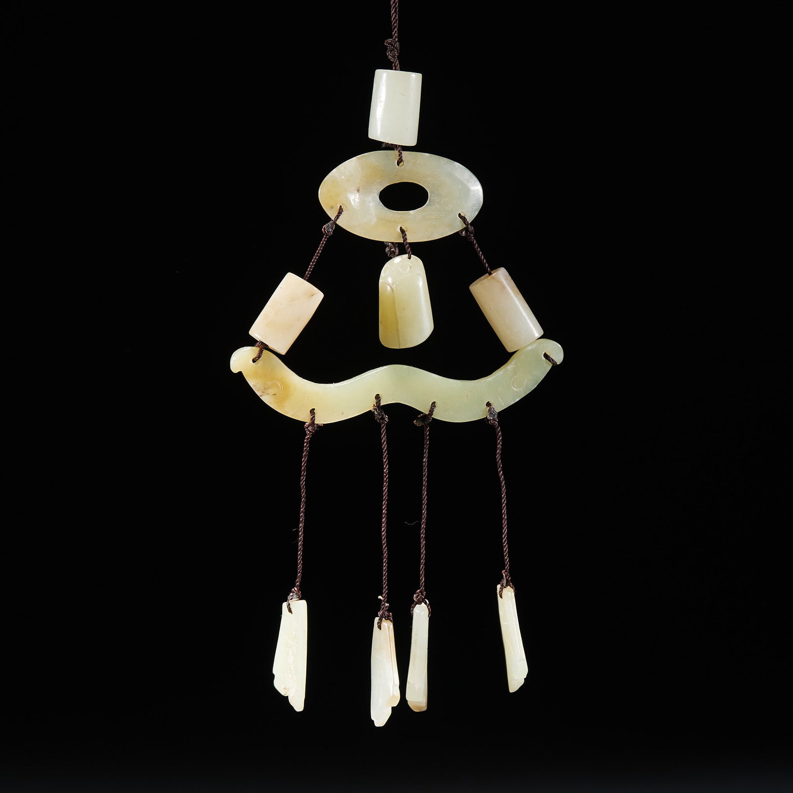 Jade Pendant Set: A complete strung jade pendant of a jade heng, bi, tube and drop linked together; the jade is warm and light-yellow ?? a composite pendant worn by ancient nobles. H 15 cm, L 8 cm, W 1 cm, 35 g.