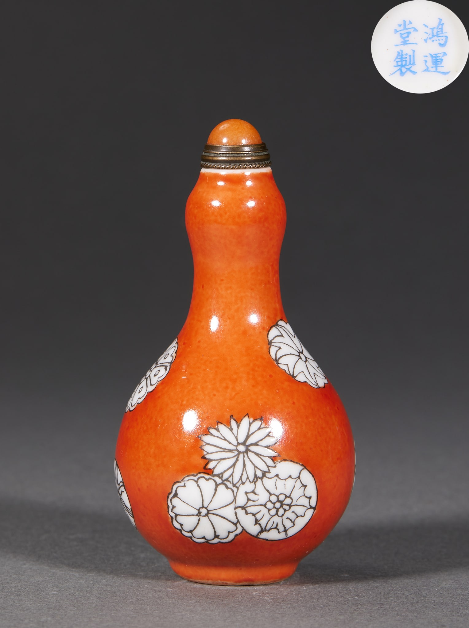 Hongliantang-Marked Floral Snuff Bottle: A porcelain snuff bottle on an iron-red glaze ground painted with white 'leather-ball' chrysanthemum patterns, with an agate stopper. The base bears the mark 'Made at Hongyuntang'; gourd-form ?? a Qin