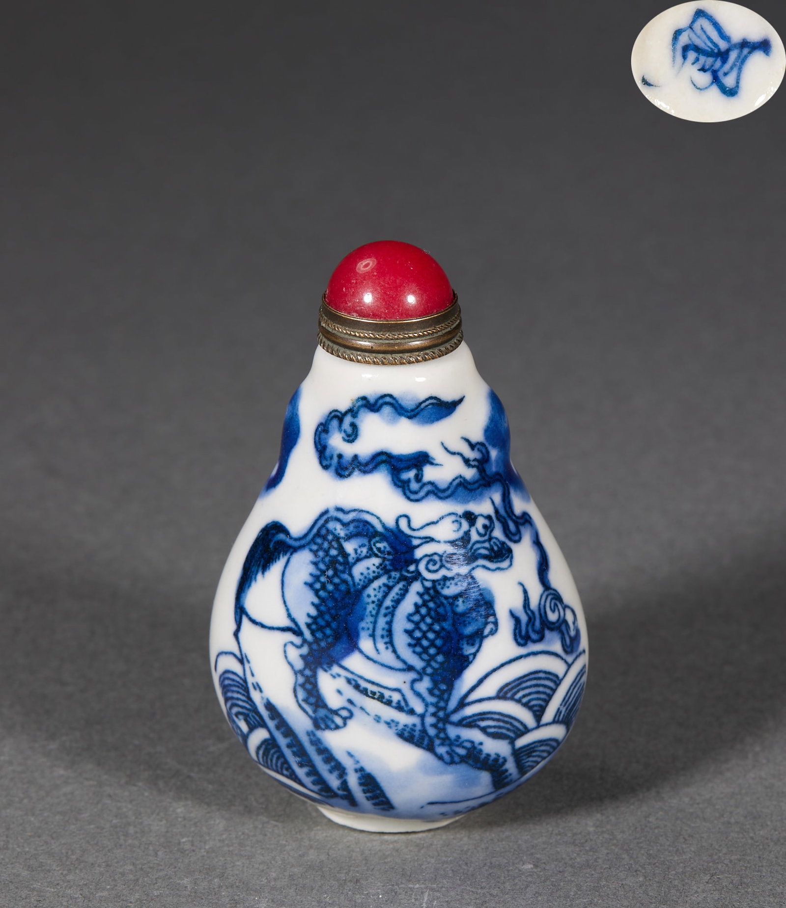 Qing Qilin Snuff Bottle: A Qing snuff bottle decorated with a qilin looking back with a majestic air. Small and rounded, of glass or porcelain, fitted with a coral or agate stopper. Overall warm in colour; the motif of good o