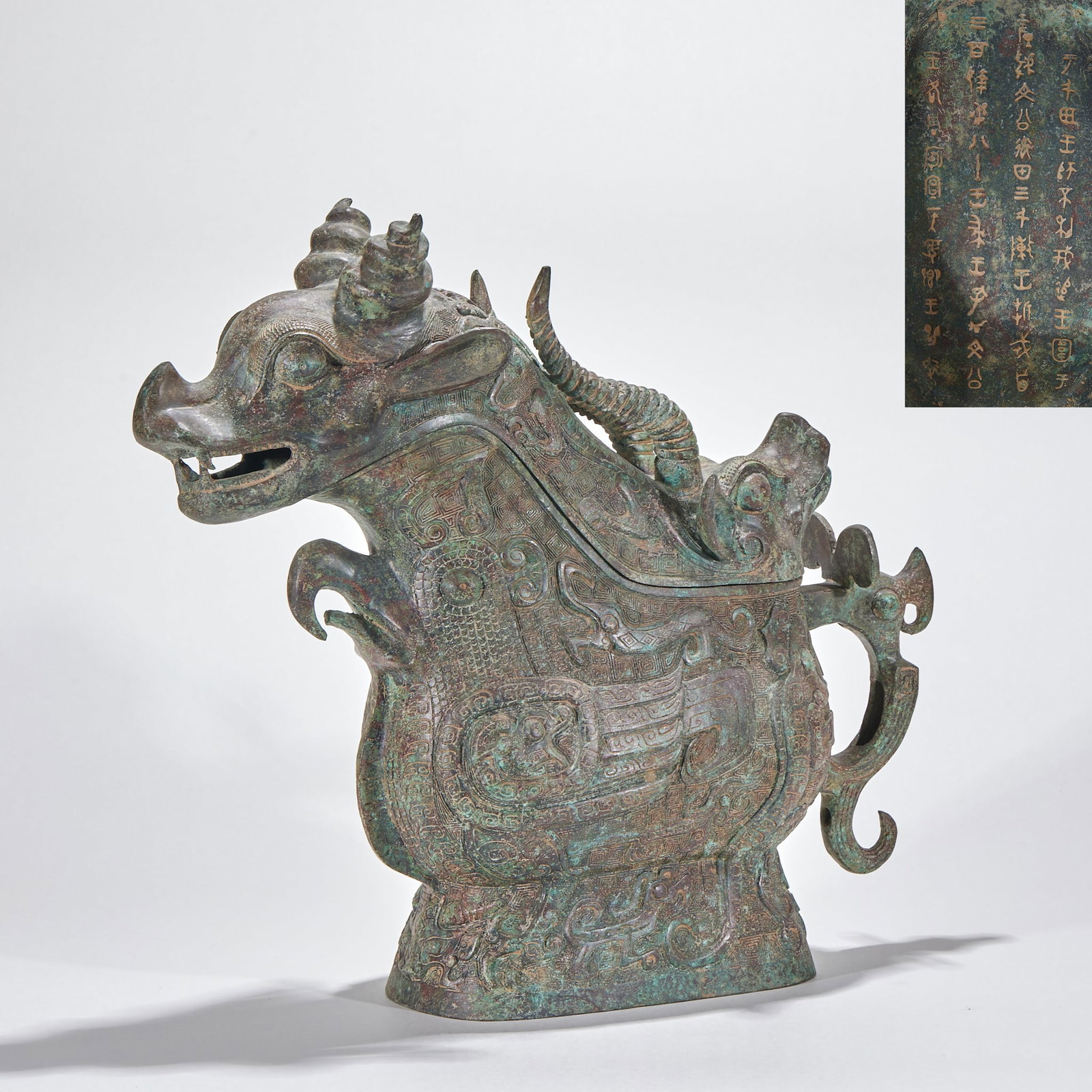 Western-Zhou Beast-Form Gong Vessel: A Western-Zhou bronze beast-form gong: the vessel takes a beast shape with raised head, round staring eyes and curving horns, decorated with taotie and kui-dragon patterns in dense relief. Imposing