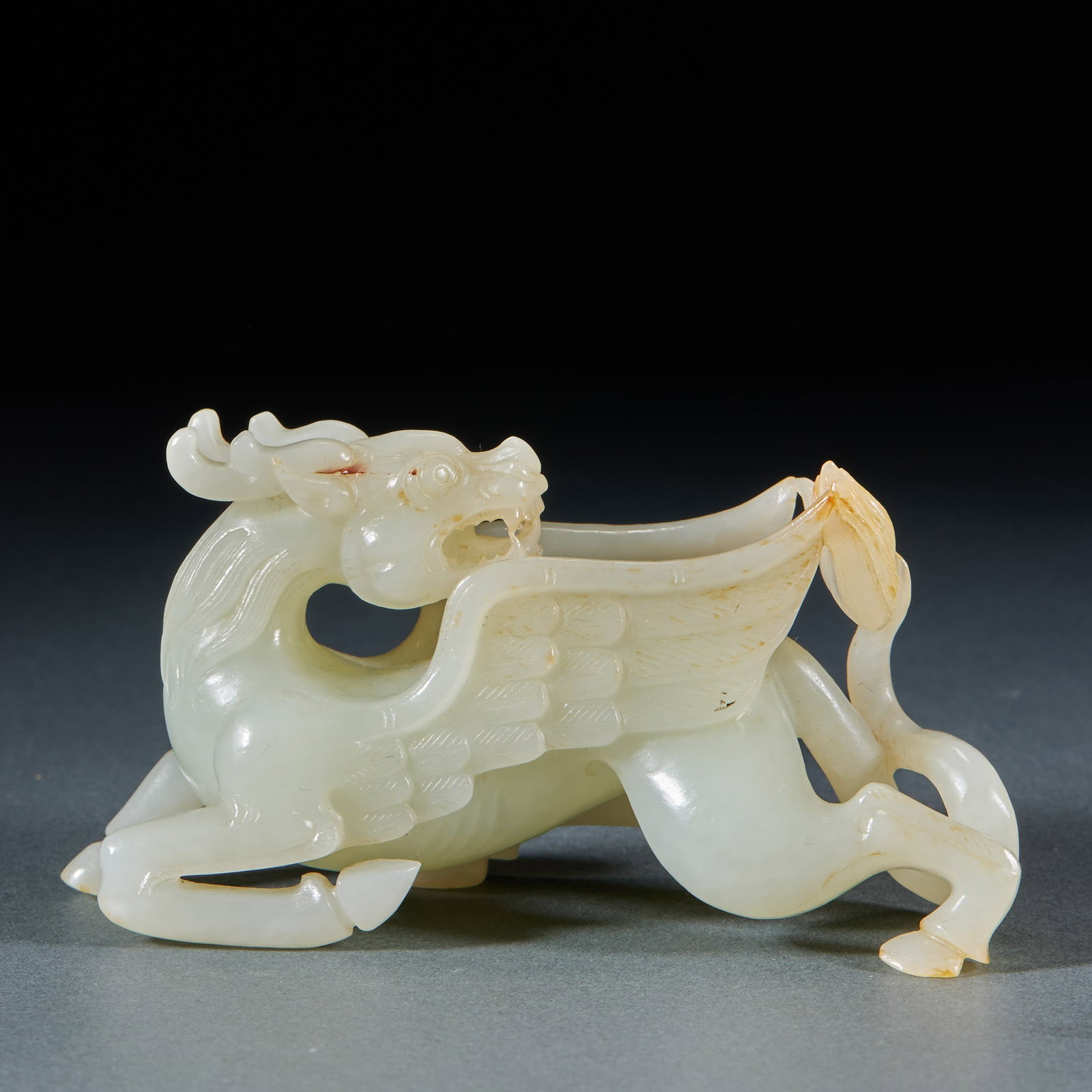 Qing Hetian Jade Dragon Ornament: A Qing Hetian jade round carving of a dragon, body coiling with raised head and sweeping tail, vigorous. The jade is warm, fine and oily, partly with skin colour; carving lines fluid and the dragon fi
