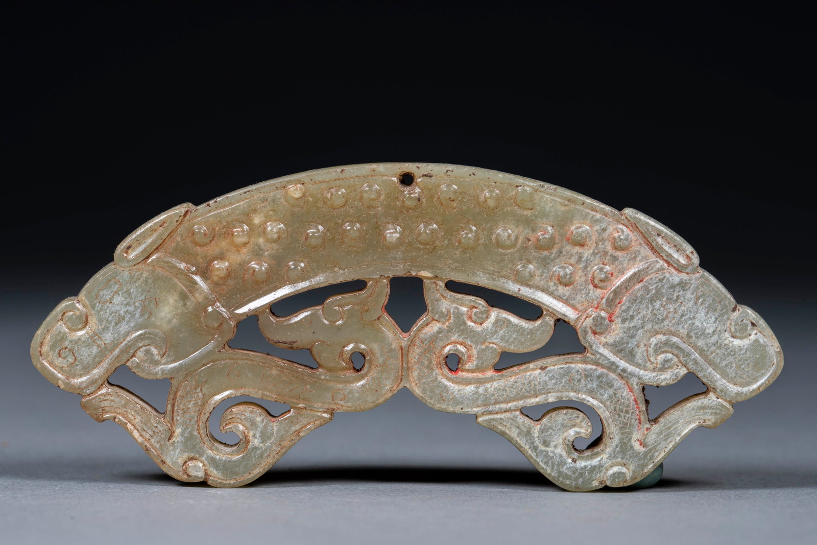 Four-Dragon Openwork Grain-Pattern Jade Huang: A jade huang arc cut in openwork combining grain (gu) patterns with four dragons, the dragons coiling and the face covered with grain. Fine jade and exquisite openwork ?? a fine archaic pendant jade. 