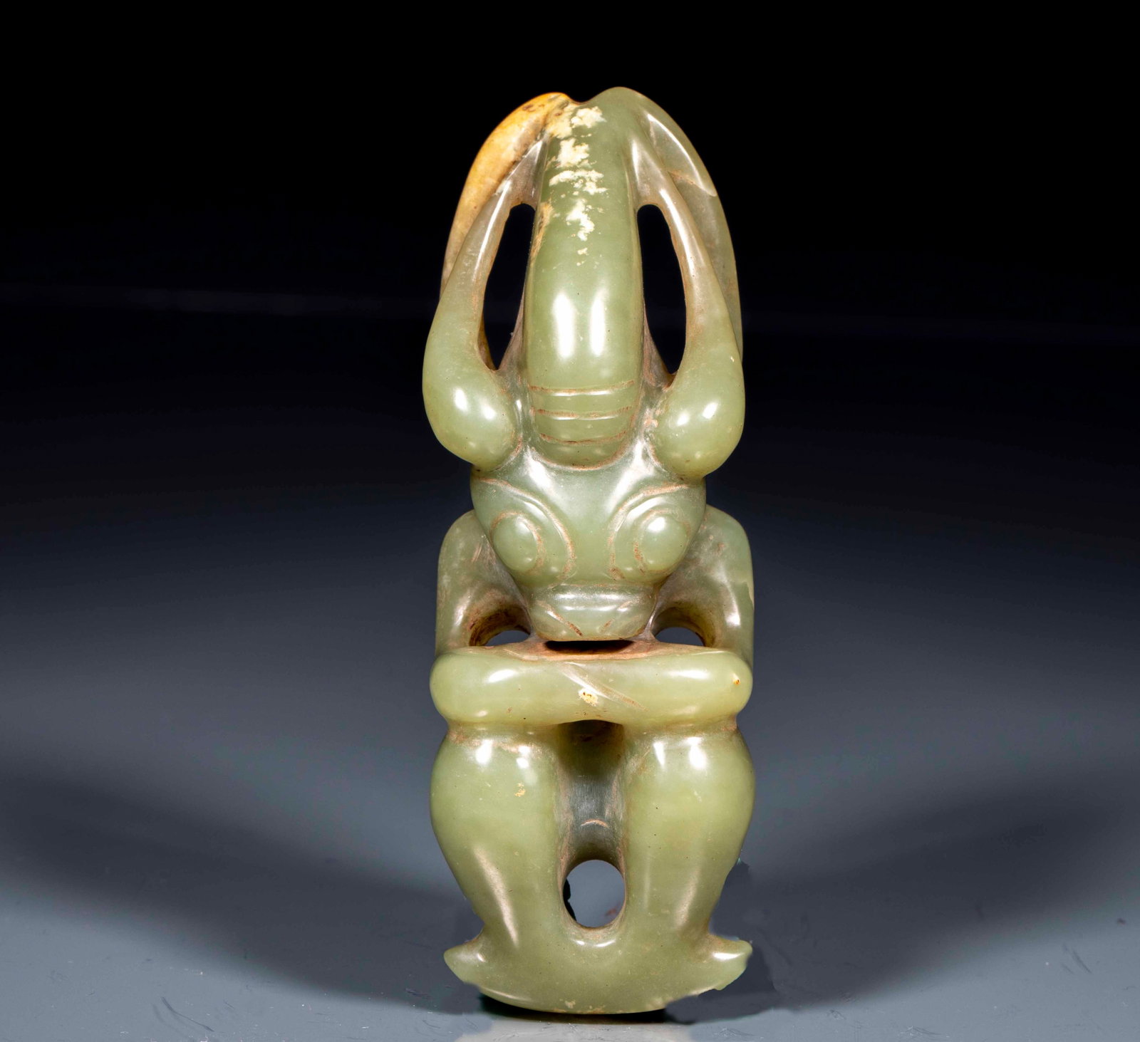 Jade Sun-God: A jade Sun-God ornament carved as a solar deity figure, human-headed or crowned, solemn of face, sometimes squatting. The jade is warm with calcification ?? a high-antiquity solar-worship subject, mys