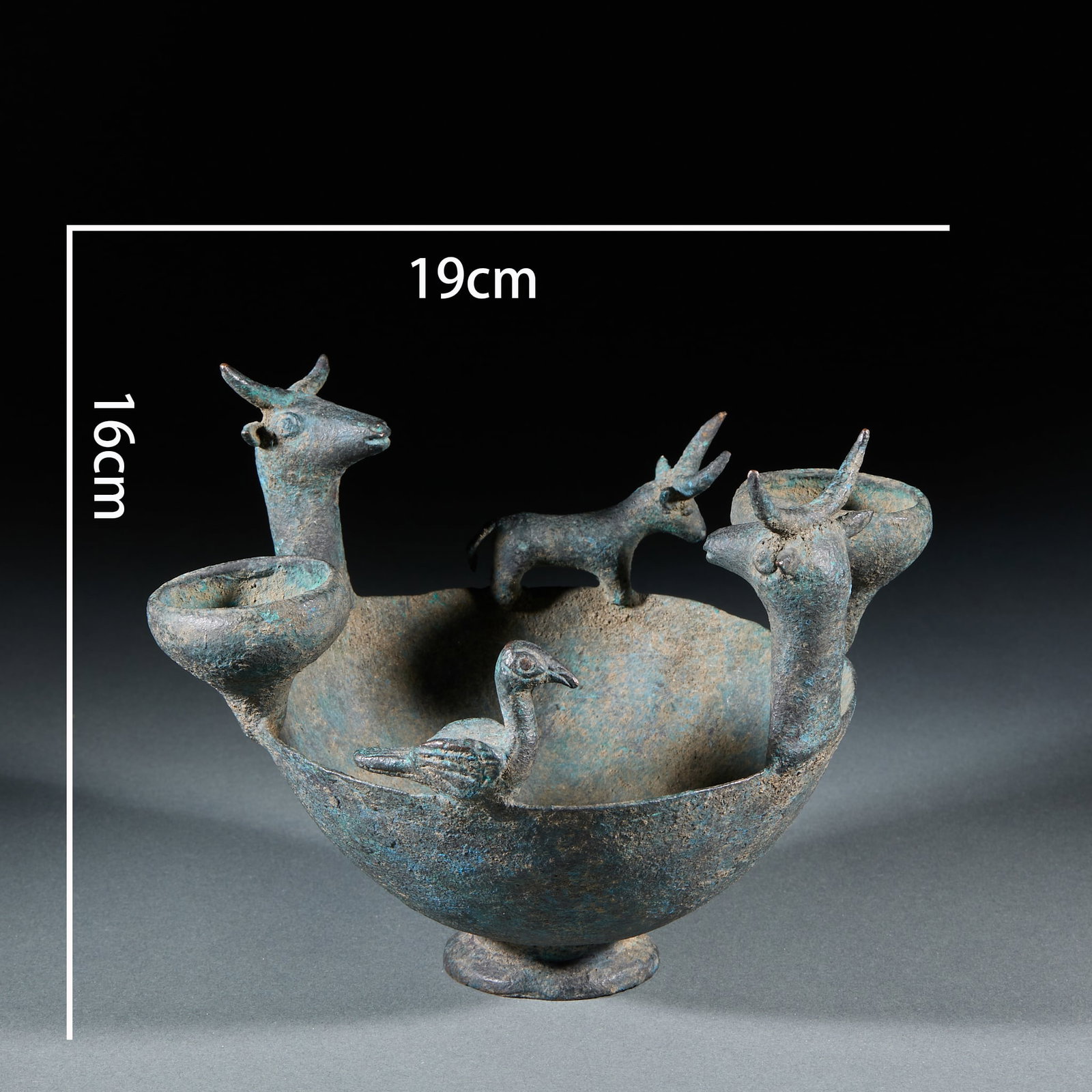 Bronze Twin-Deer Three-Lamp Lamp: A bronze lamp whose base models two deer in lively poses; the pan is triple-lamp, able to burn several flames. Unusual in form, covered in green patina ?? a Han bronze lamp. H 16 cm, Diameter 19 cm.