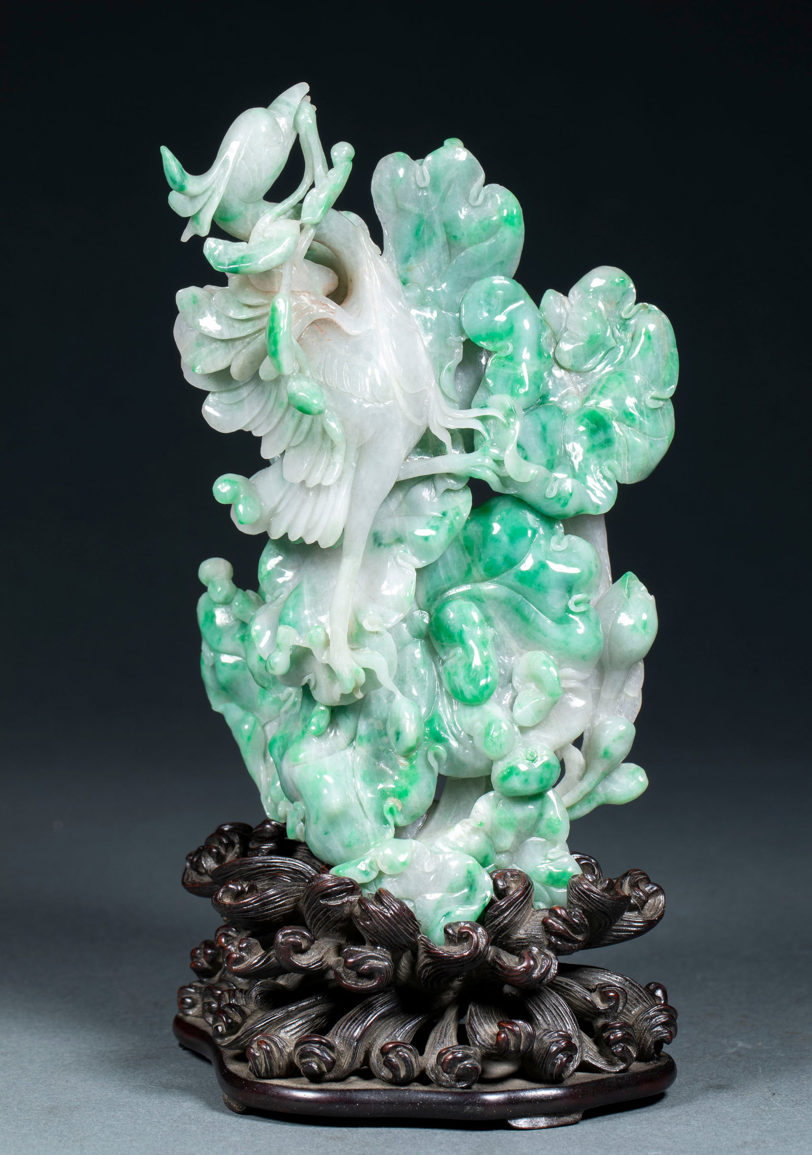 Jadeite Phoenix Ornament: A jadeite round carving of a phoenix, wings spread and head raised, tail splendid. The jadeite is green and warm, finely carved. The phoenix symbolises good omen ?? a fine scholar's desk piece. H