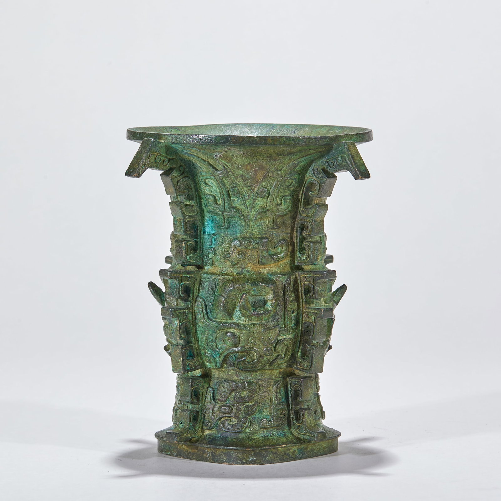 Pre-Ming Bronze Zun: A bronze zun, an ancient wine ritual vessel, round or square, rounded belly and high foot, with shoulder decoration. Covered in green patina, dignified ?? a pre-Ming bronze ritual vessel. H 13 cm,