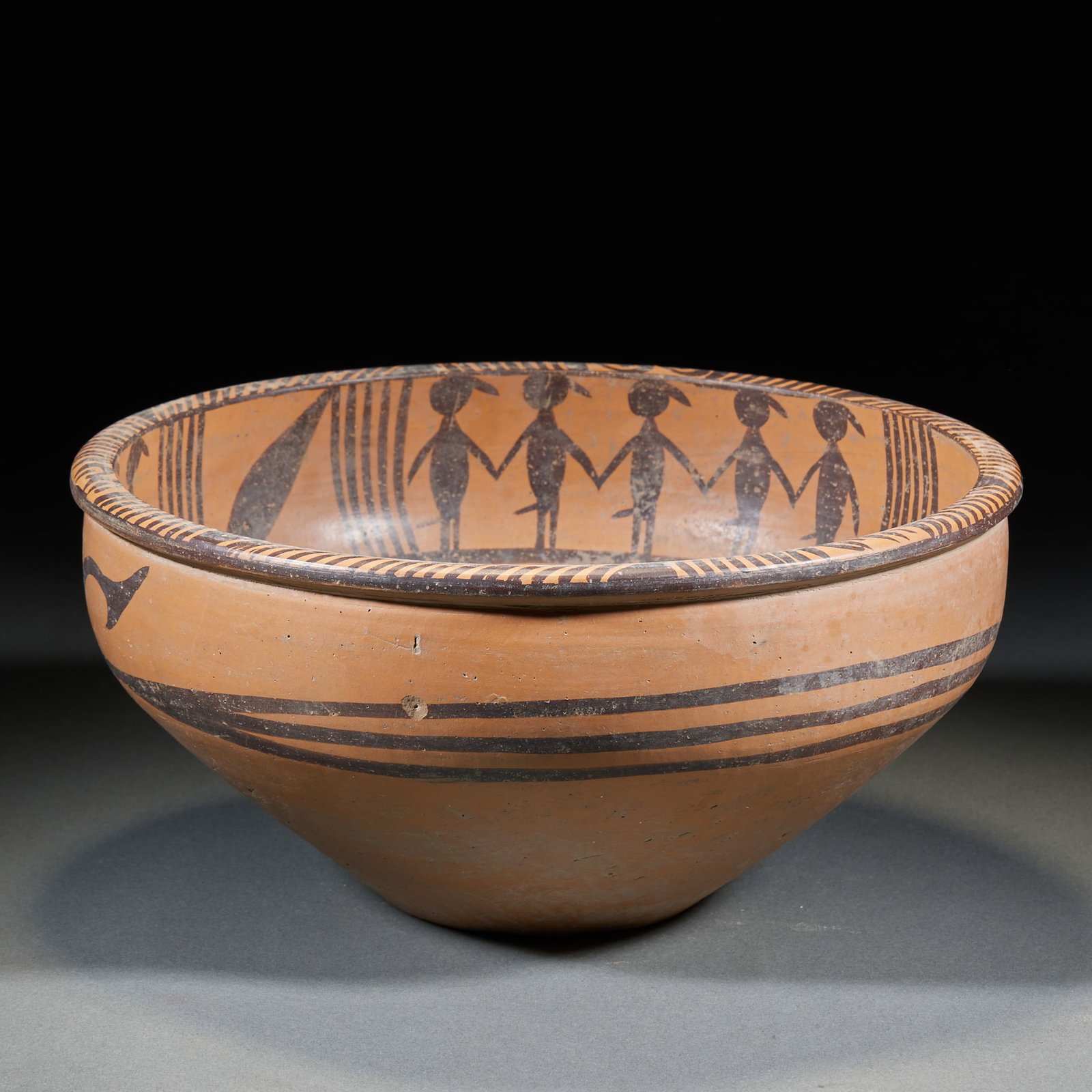 Majiayao Culture Dance-Figure Painted Basin: A Majiayao culture dance-figure painted basin of fine red earthenware; the inner wall is painted in black with dancing human figures, hand in hand in lines ?? lively. A prehistoric dance motif of