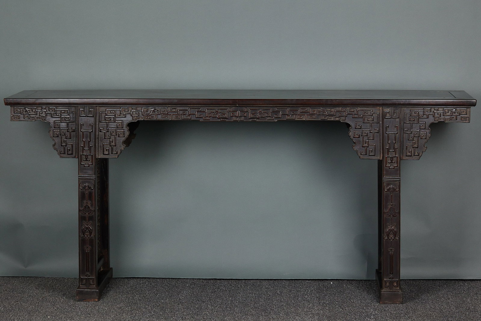 Zitan Long Table: A zitan long table with a flat top, sturdy legs and simple structure. Deep-toned, oily wood with a warm patina ?? Ming-style furniture for display and writing, dignified. H 87.5 cm, L 199 cm, W 44 cm.