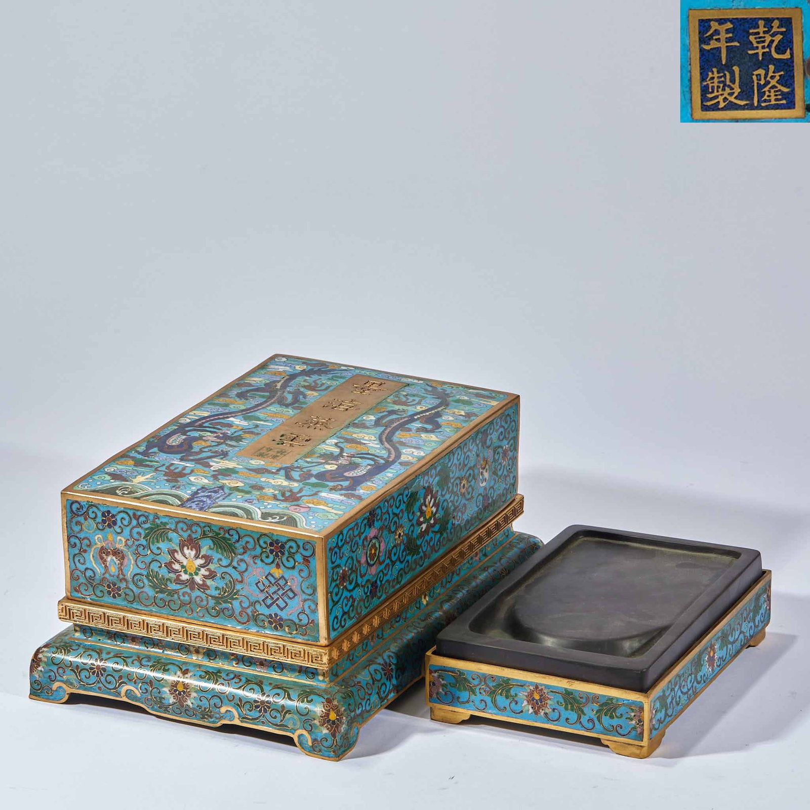 Qianlong Cloisonne Box Inkstone: A Qianlong-marked cloisonne inkstone decorated with floral motifs in bright enamels, the base bearing the Qianlong mark. Both practical and decorative ?? an imperial scholar's piece. Box H 12.5 cm, L