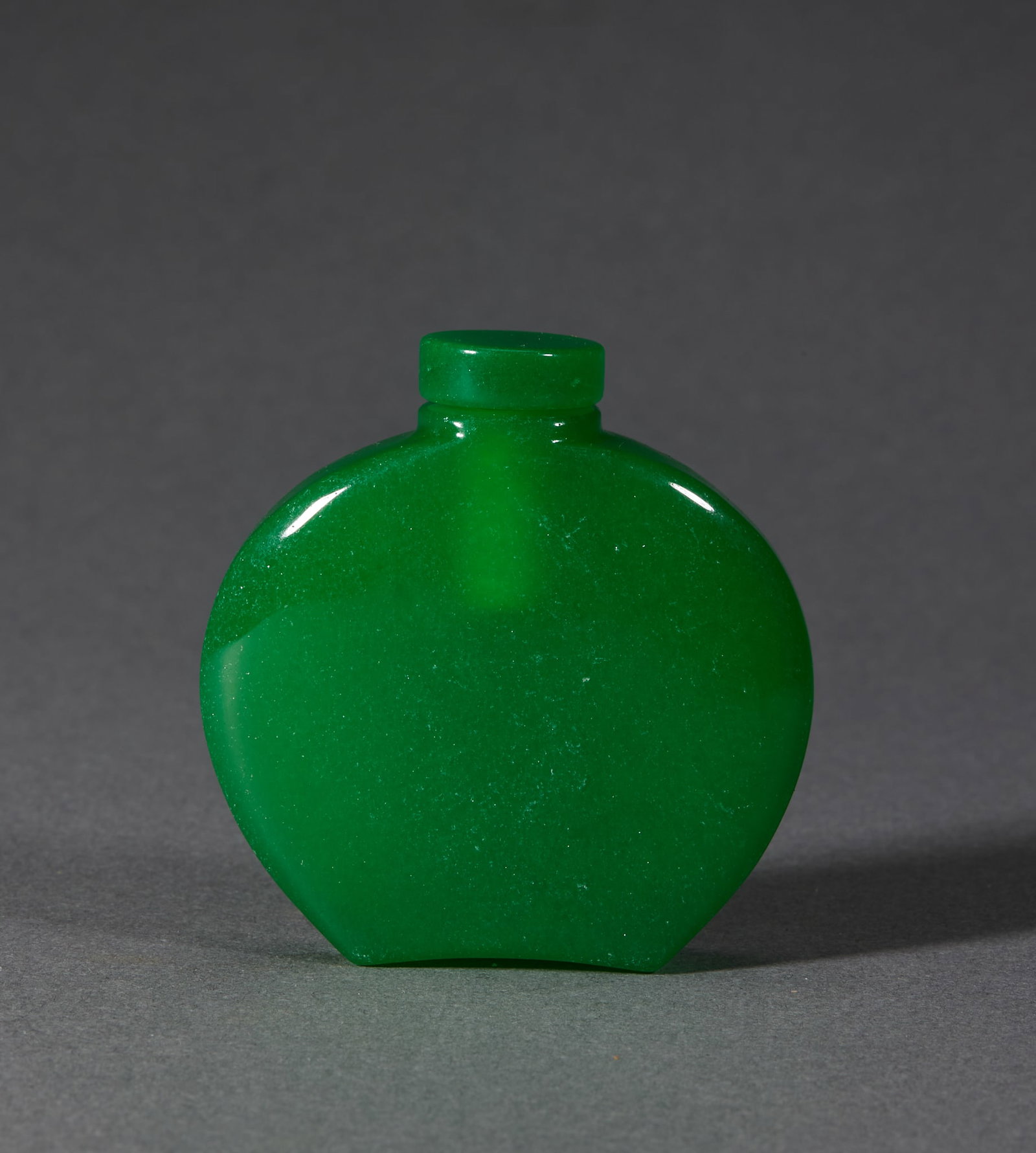 Qing Jadeite Snuff Bottle: A Qing jadeite snuff bottle, warm quality, green or greenish. Small with a stopper, plain or lightly carved ?? among snuff bottles of precious material. H 5.1 cm, L 5.1 cm, W 1.3 cm, 68 g.