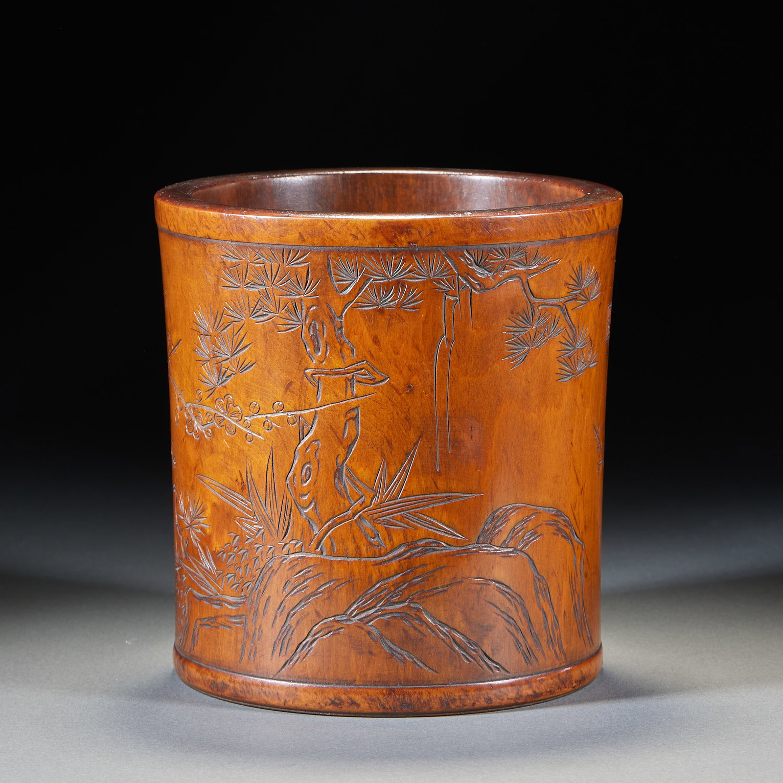 Huanghuali Pine-Plum Poem Brush Pot: A Huanghuali brush pot with the exterior carved in relief with a pine-and-plum scene ?? pine and plum flourishing, symbolising integrity and endurance ?? and an inscribed poem on the other face. Beaut