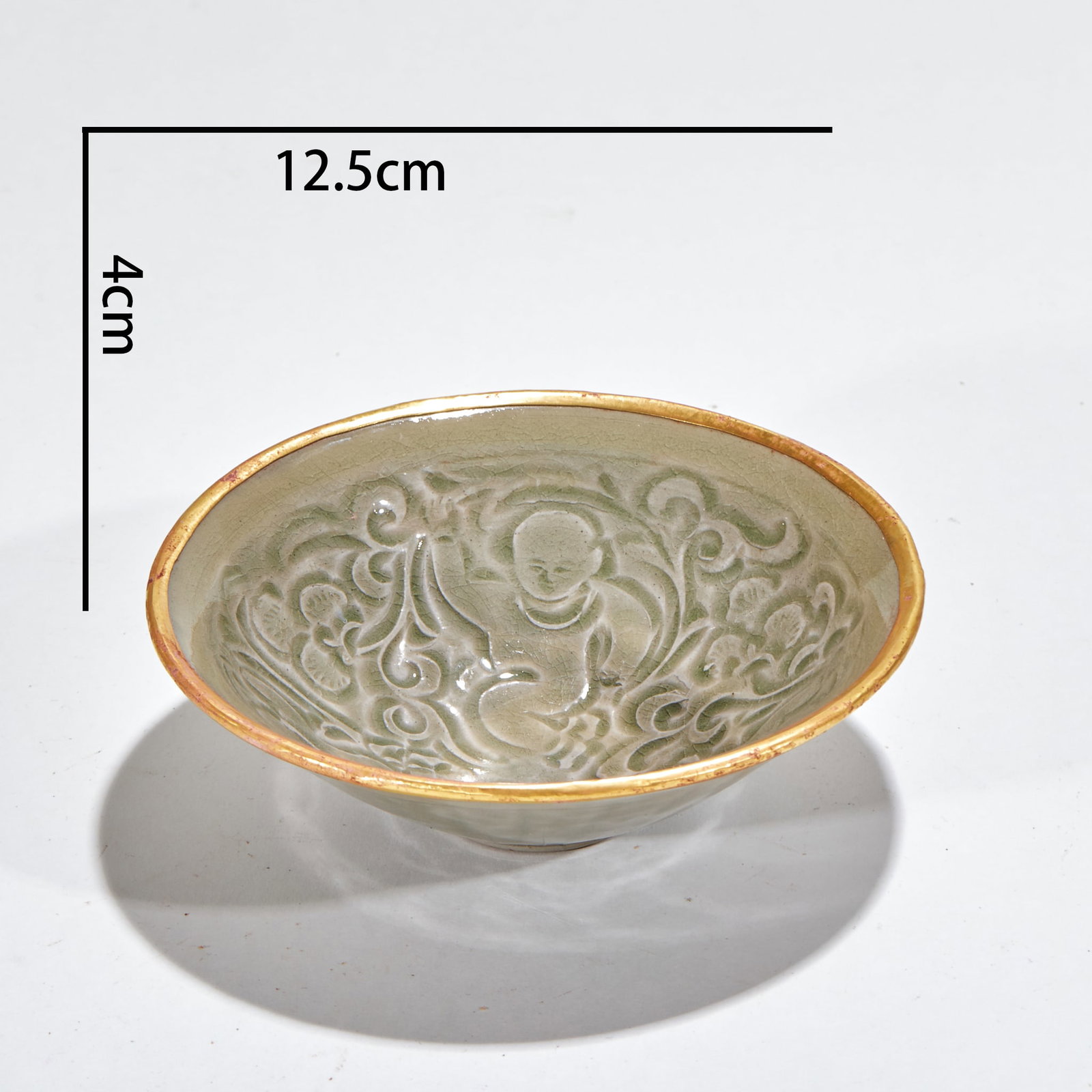 Northern-Song Yaozhou Kiln Children-at-Play Cup: A Yaozhou cup carved with a children-at-play scene, lively boys. Warm celadon and fine carving ?? a celebrated Yaozhou piece. H 4 cm, Diameter 12.5 cm.