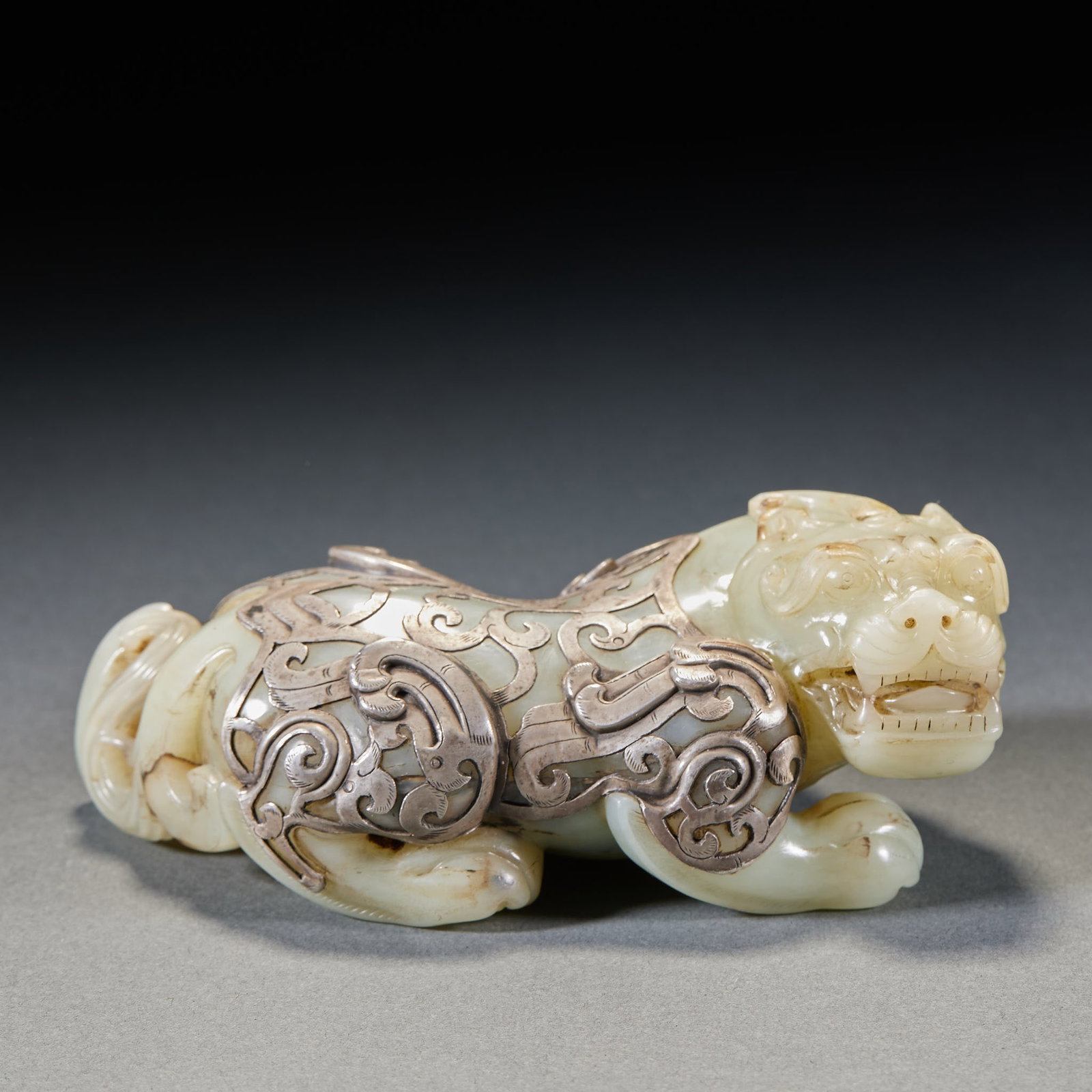 Silver-Wrapped Jade Beast: A jade auspicious-beast ornament wrapped in silver, gold and silver shining together. The jade is warm, the silver fine, the beast fierce ?? a display ornament. H 5 cm, L 12.5 cm, W 7.5 cm, 636 g.