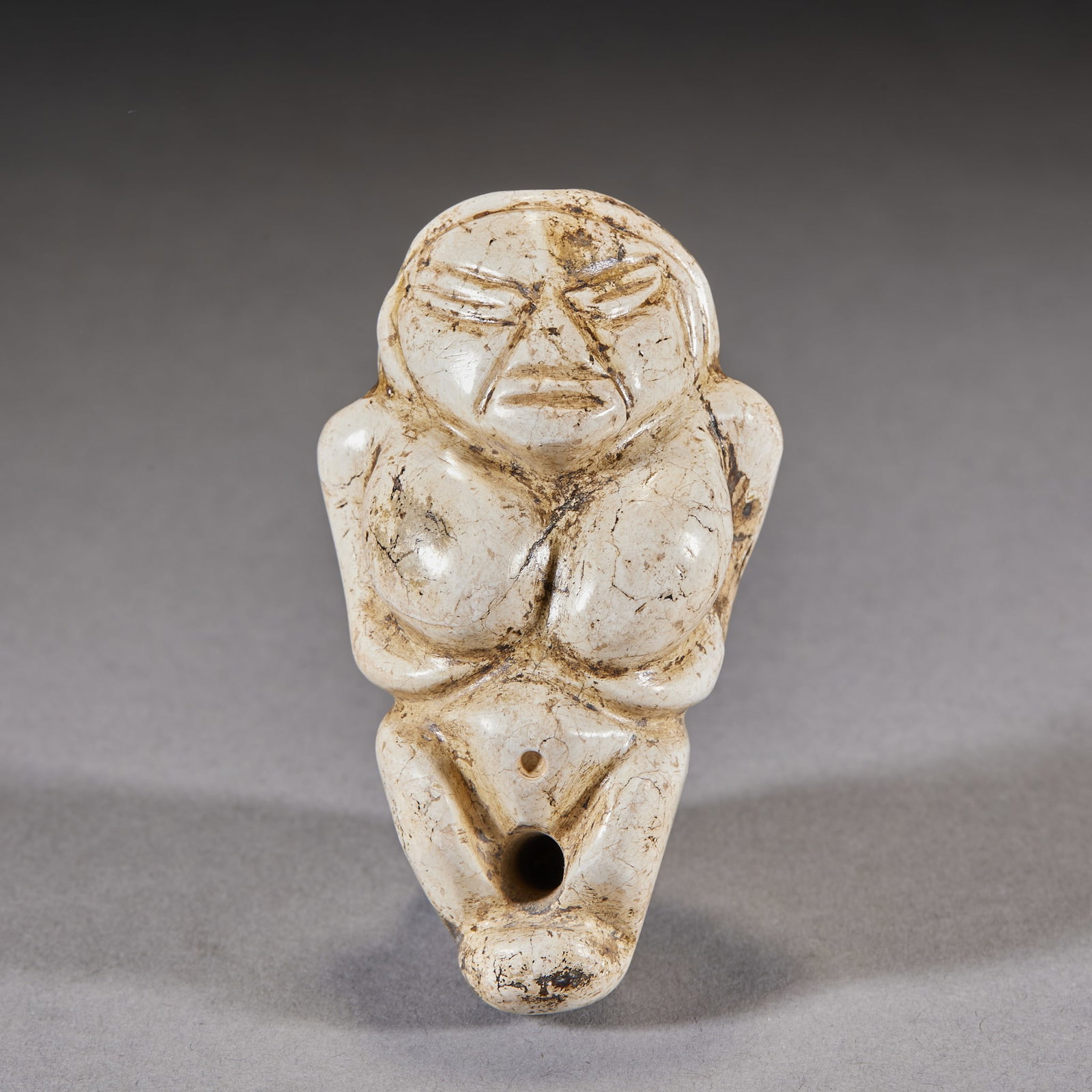 Hongshan Chicken-Bone-White Jade Figure: A Hongshan chicken-bone-white jade figure, simple and archaic, solemn of face. A Hongshan-culture jade figure of primitive religious meaning and great value. H 6.5 cm, L 4 cm, W 3.5 cm, 83 g.