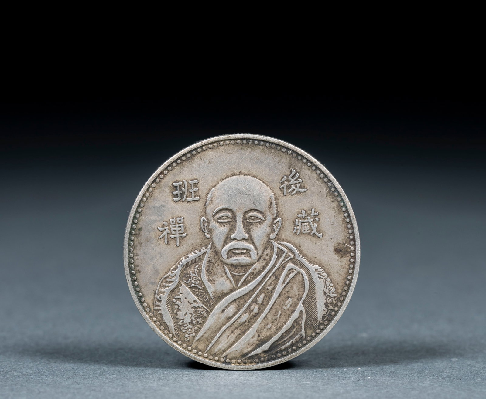 Post-Tsang Panchen Silver Coin: A silver coin bearing Tibetan script or designs, associated with the Panchen of the Tsang region. Warm silver ?? a modern Tibetan local coin of historical and collecting value. Diameter 3.9 cm, 26.5