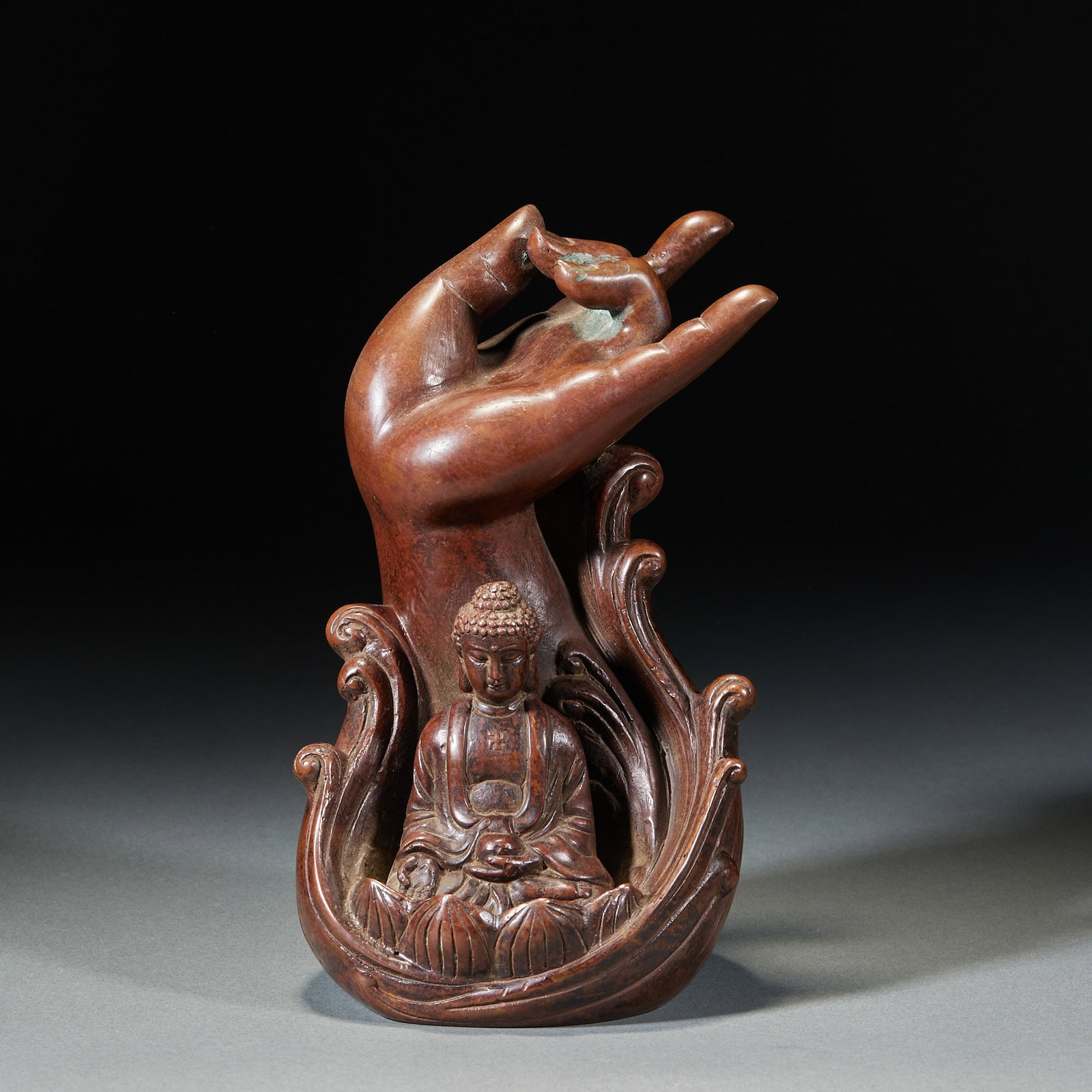 Copper Seated Medicine-Buddha with 'Five-Finger Mountain' Reverse-Flow Incense Holder: A copper seated Medicine Buddha on a lotus throne holding a bowl or in a mudra; beneath the seat is a 'Five-Finger Mountain' incense holder through which smoke flows downward ?? ingenious, a display