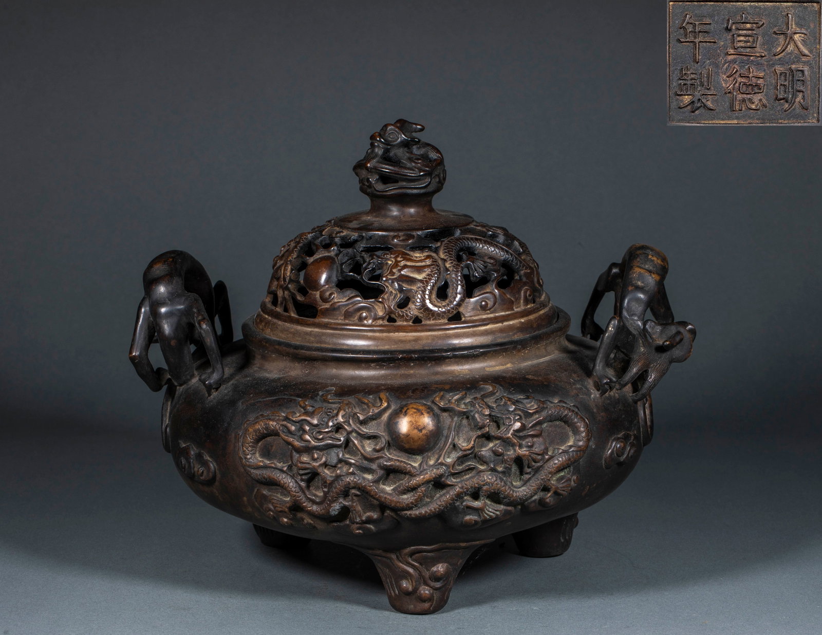 Xuande-Marked Twin-Dragons-Chasing-Pearl Dragon-Head Incense Burner: A Xuande-marked twin-dragons-chasing-pearl dragon-head incense burner: the body decorated with twin dragons chasing a pearl, the ears or spout as dragon heads, the base bearing the mark 'Made in the