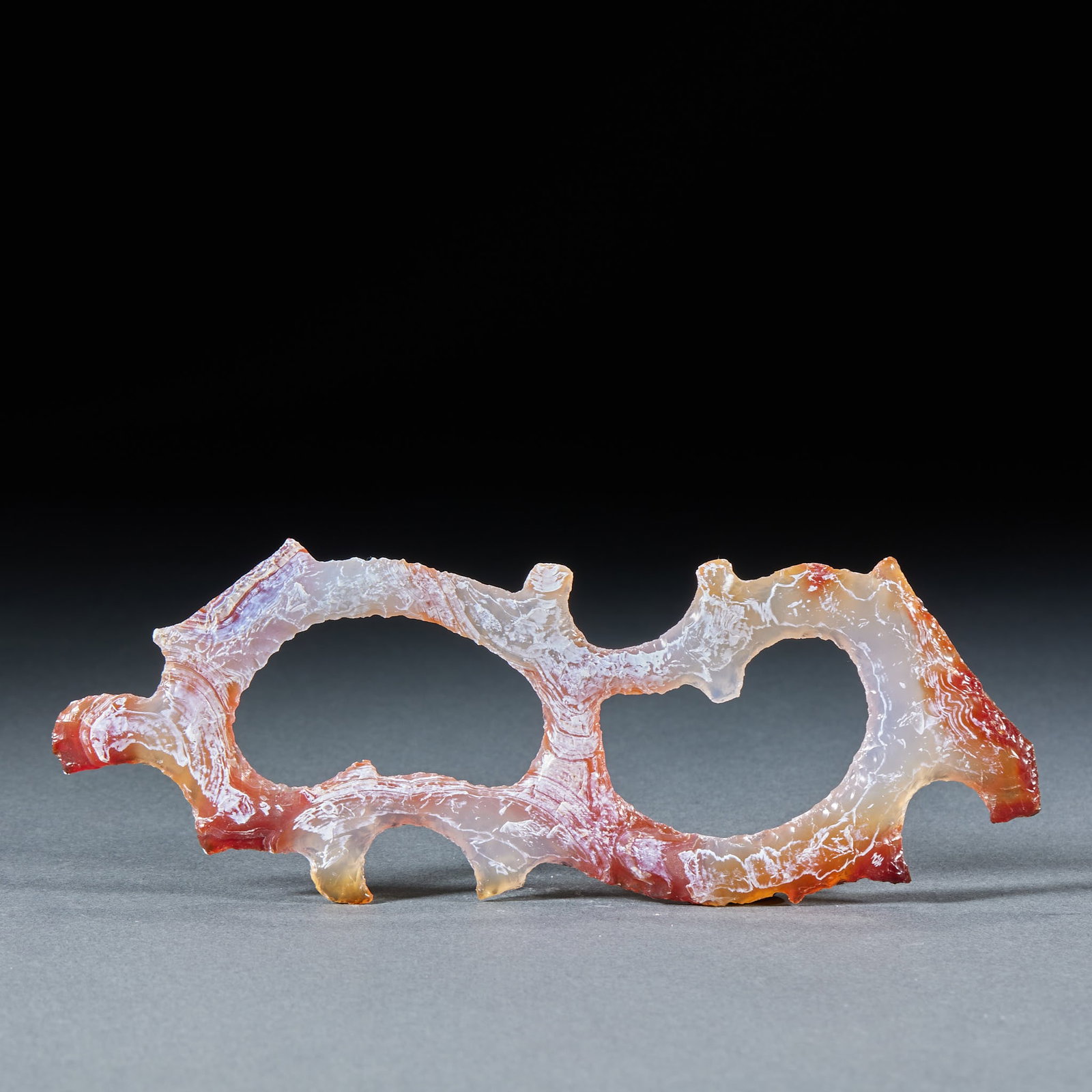 Agate Curled-Cloud Pendant: An agate pendant carved with curling-cloud patterns, coiling and flowing, magnificent grain. With a hole at the top for stringing ?? a fine pendant. L 15 cm, W 5.5 cm, 31 g.