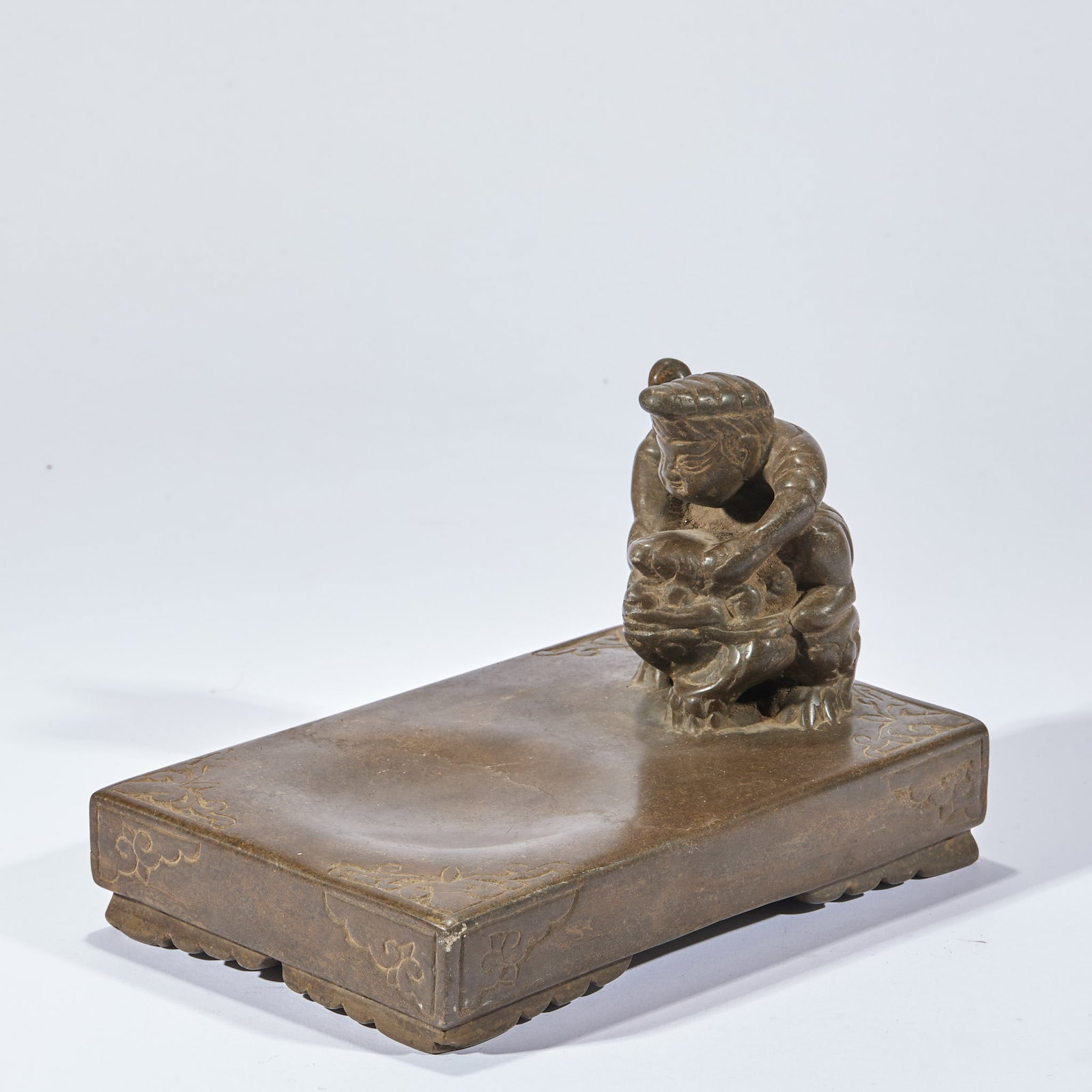 Figure Inkstone: An inkstone carved with a figure motif, the figure lively. Warm stone, good for grinding ink ?? a scholar's inkstone, practical and decorative. H 15 cm, L 22.5 cm, W 15 cm.