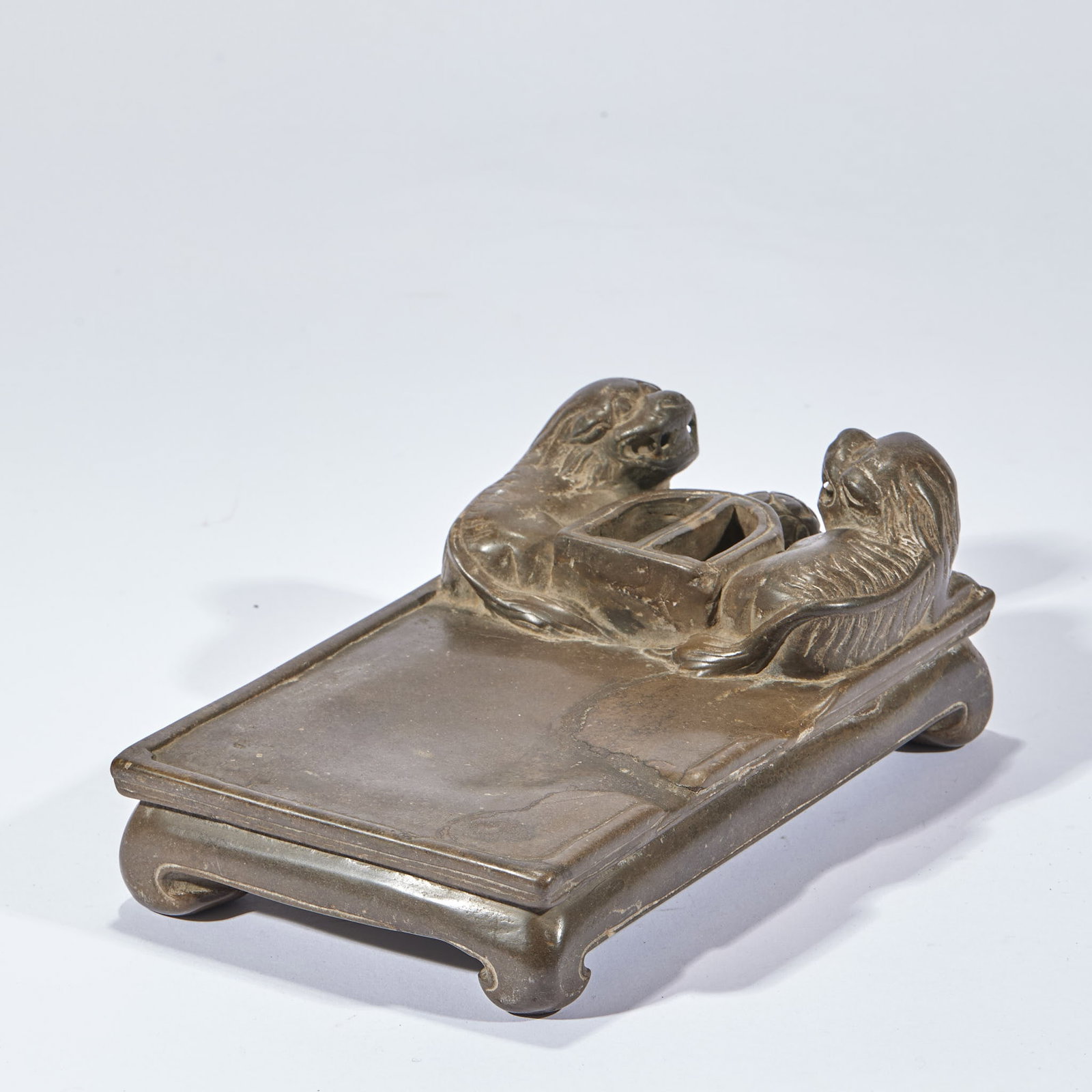 'Grand Tutor and Junior Tutor' Inkstone: An inkstone carved with a large and a small lion, punning on 'grand tutor and junior tutor', symbolising high rank and office. Warm stone and fine carving ?? a scholar's inkstone. H 8 cm, L 20.5 cm,