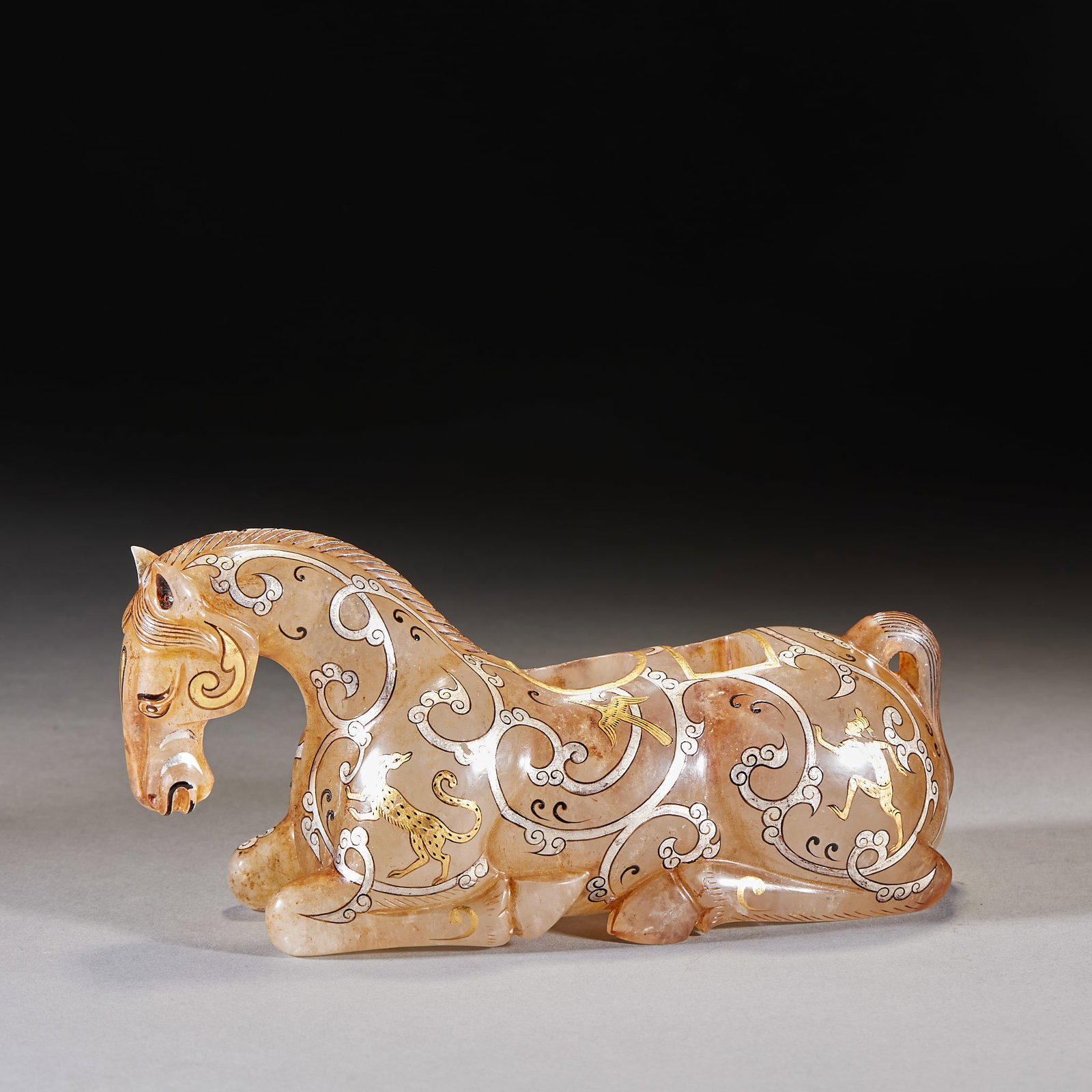 Han-Dynasty Jade Gold-Inlaid Reclining-Horse Vessel: A Han jade reclining-horse vessel: the horse reclines, inlaid with gold and silver, gold and silver shining together. Warm jade and fine craft ?? a fine Han jade piece. H 9 cm, L 19 cm, W 7 cm, 1241