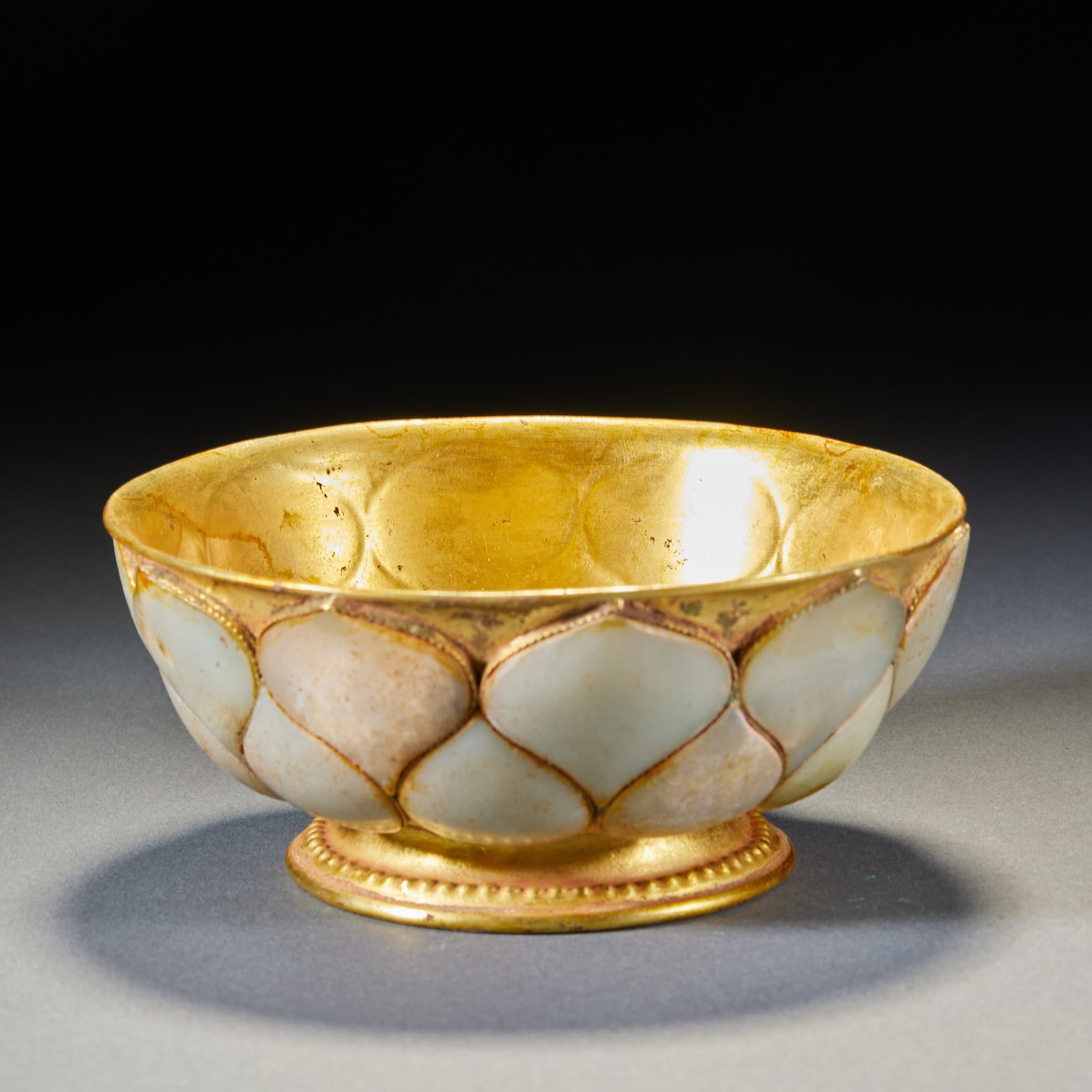 Gilt Copper Jade-Inlaid Bowl: A gilt-copper bowl inlaid with jade plaques on the body. Bright gilding and warm jade ?? a court or noble's bowl, both practical and sumptuous. H 6 cm, Diameter 13.5 cm, 486 g.