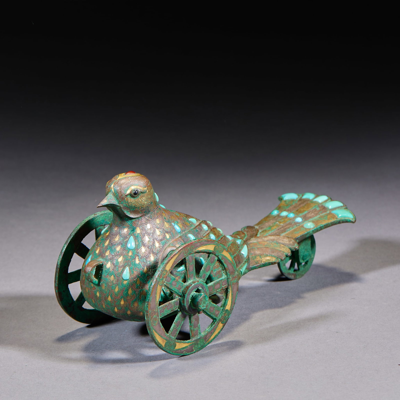 Inlaid-Gold-and-Silver Turquoise-Inset Divine-Bird Chariot: A bronze or metal model of a divine-bird chariot, inlaid with gold and silver and set with turquoise, splendid decoration. Fine craft ?? an archaic bronze. H 8.5 cm, L 17 cm, W 8.5 cm.