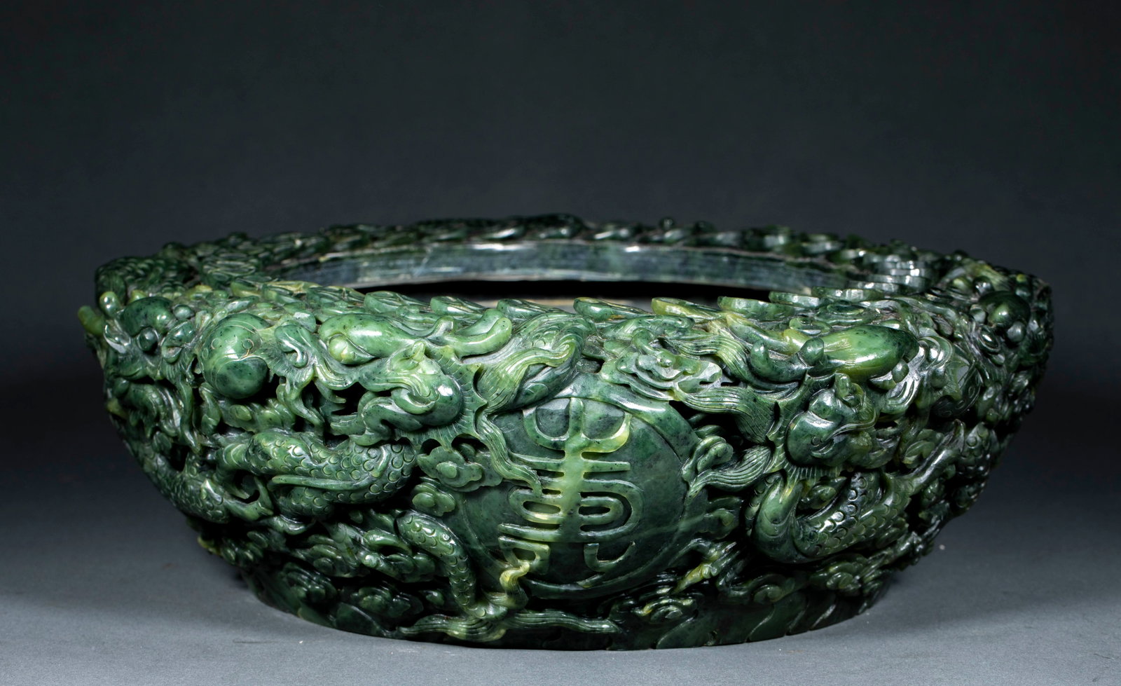 Spinach-Jade Relief Dragon Fu-Lu-Shou-Xi Brush Washer: A spinach-jade brush washer with the exterior carved in relief with dragons and the characters 'Fu Lu Shou Xi' (fortune, rank, long life, joy). Green, warm jade, fine carving ?? a scholar's brush wash