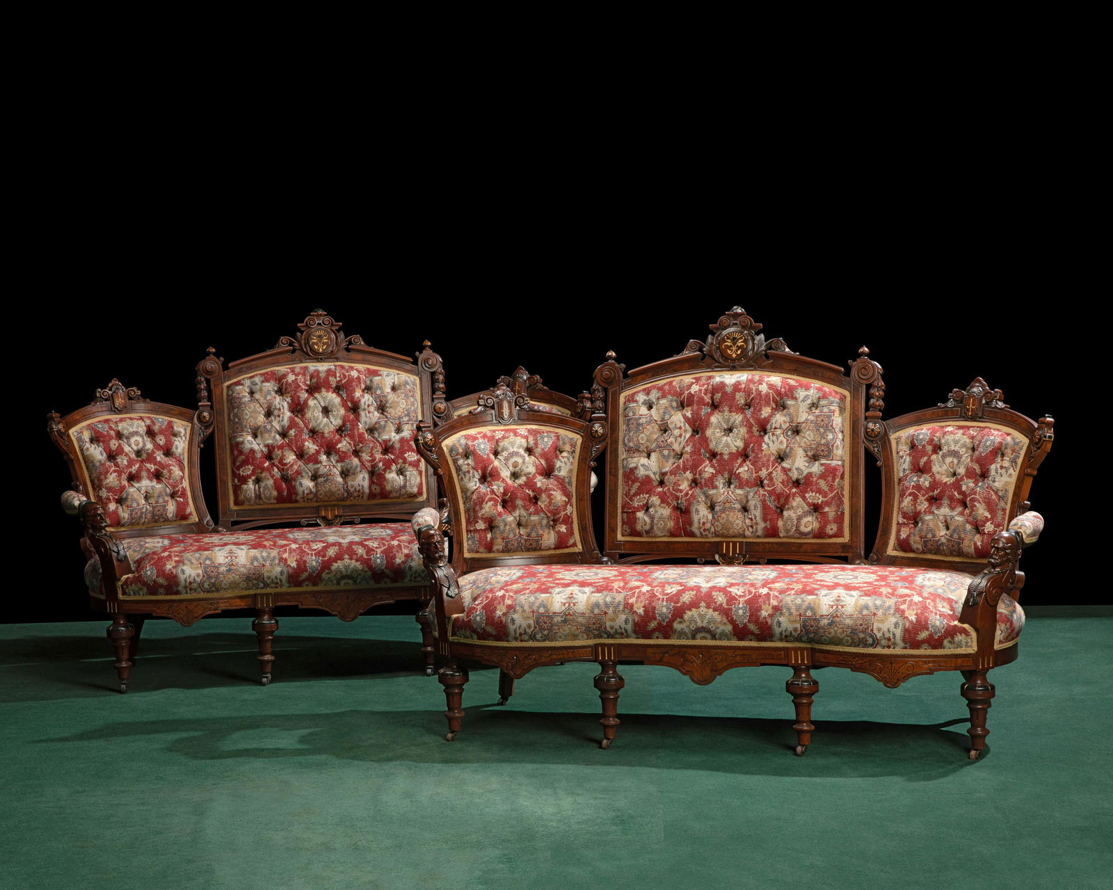 A pair of Victorian Renaissance Revival settees: A pair of Victorian Renaissance Revival setteesMid/late 19th centuryThe John Jelliff-style settees in carved mahogany and burlwood inlay with ebonized and gilt highlights with figurative arms in tufte
