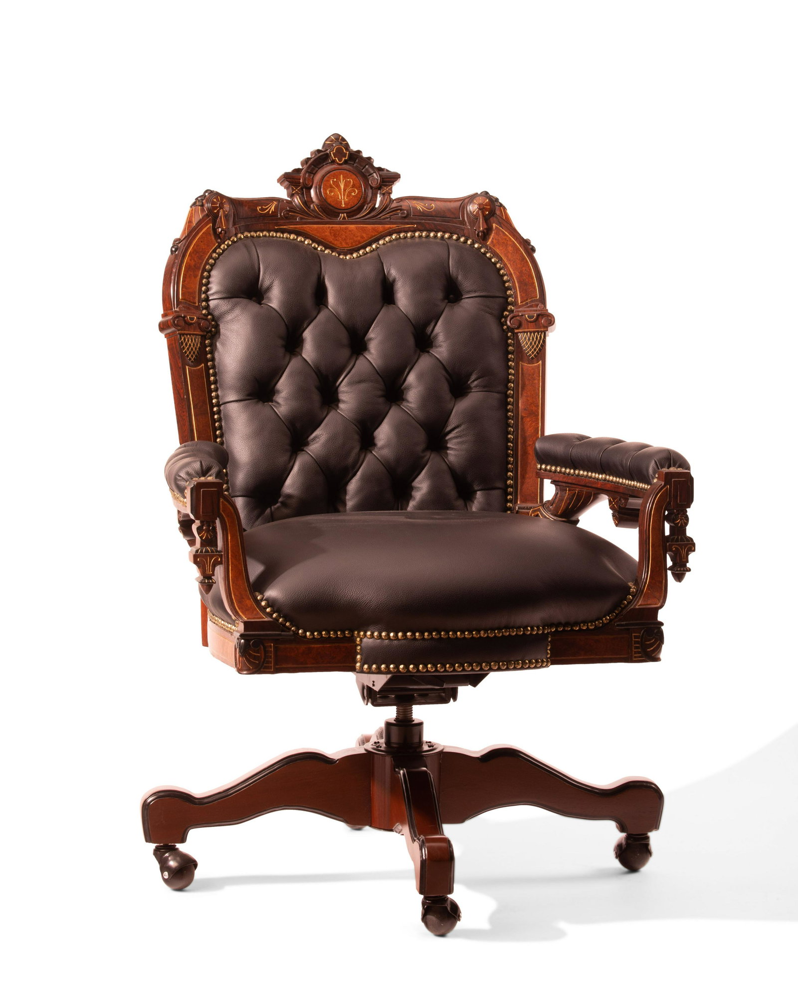 An American Victorian Renaissance Revival executive office chair: An American Victorian Renaissance Revival executive office chair 20th century Carved in walnut with burlwood inlay, with ebonized and giltwood highlights, and black tufted leather with nail head trim 