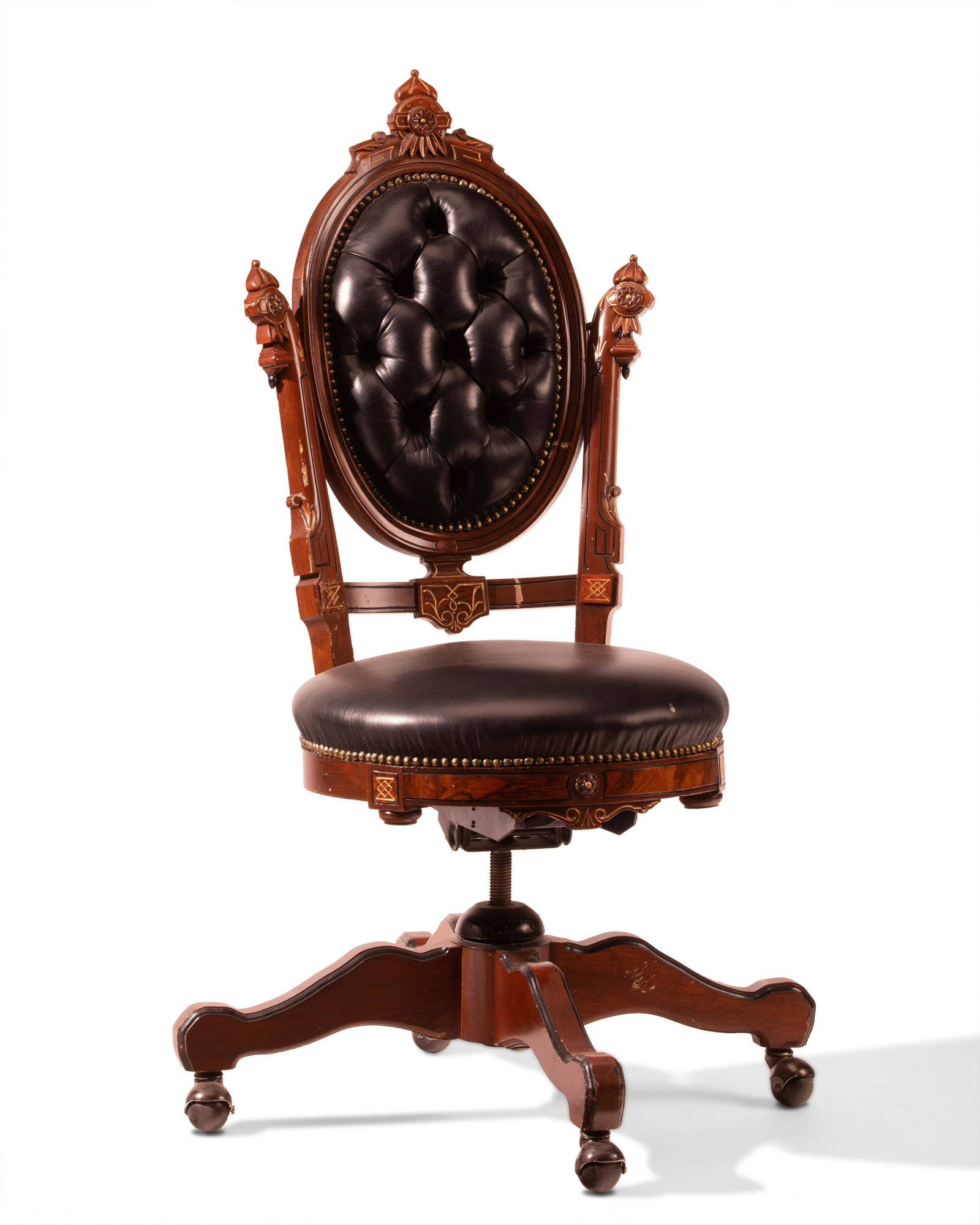 An American Renaissance Revival swivel desk chair: An American Renaissance Revival swivel desk chair 20th century Walnut with ebony and gilt details, adapted for use as a swivel desk chair on a four-arm base 55" H x 18" W x 18" D
